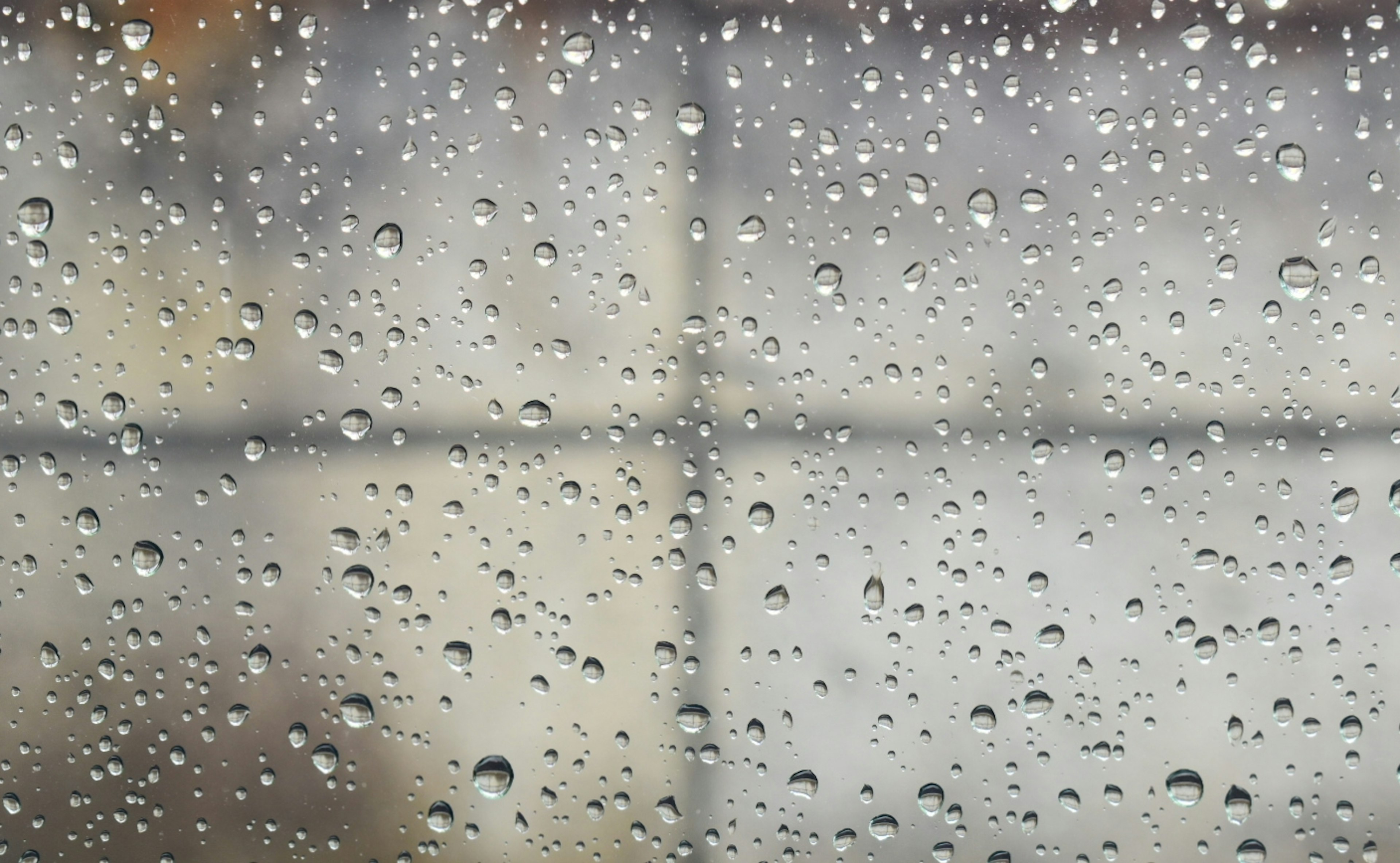 Close-up of raindrops on a window with a blurred background