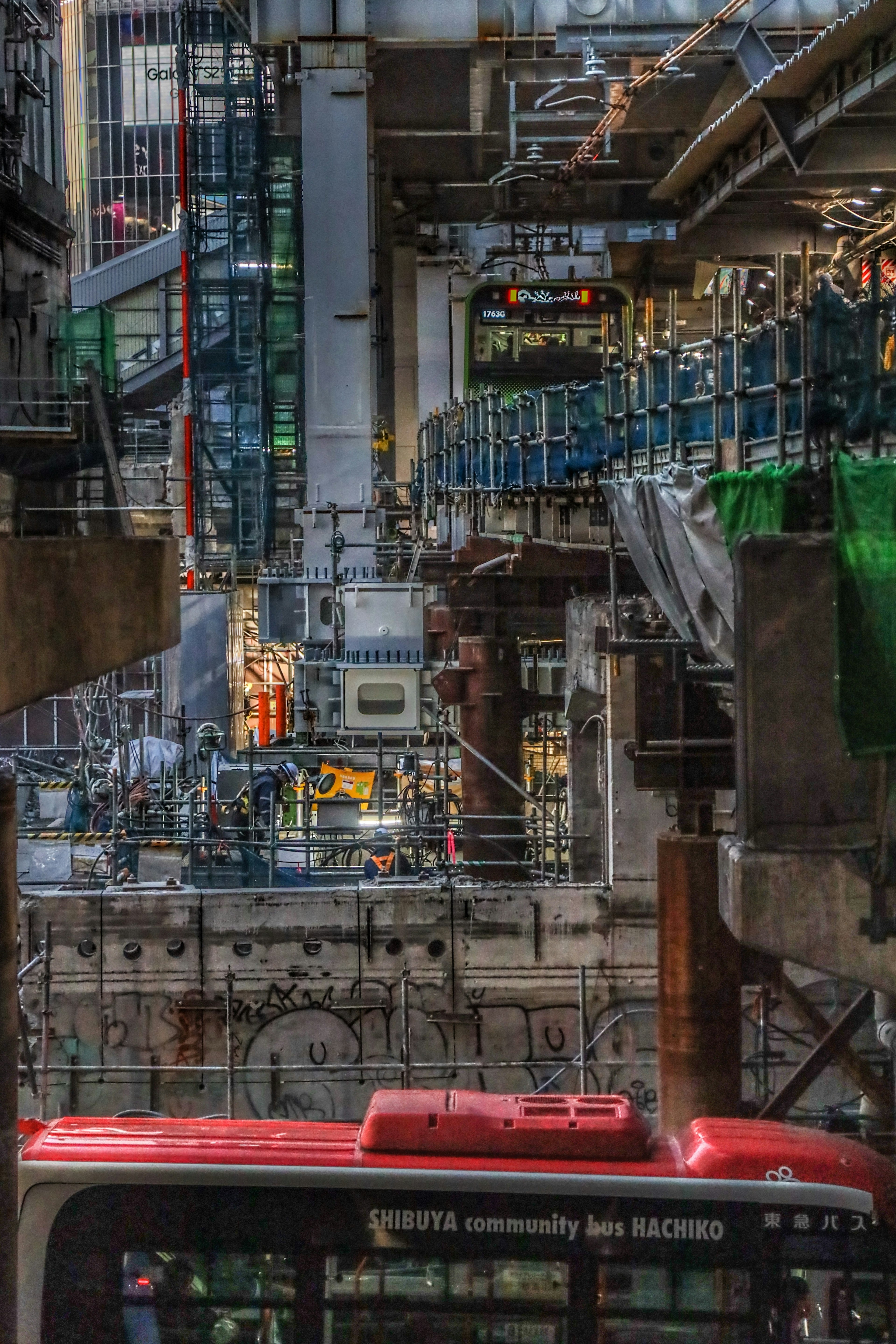 Image montrant un équipement industriel complexe avec un bus rouge au premier plan