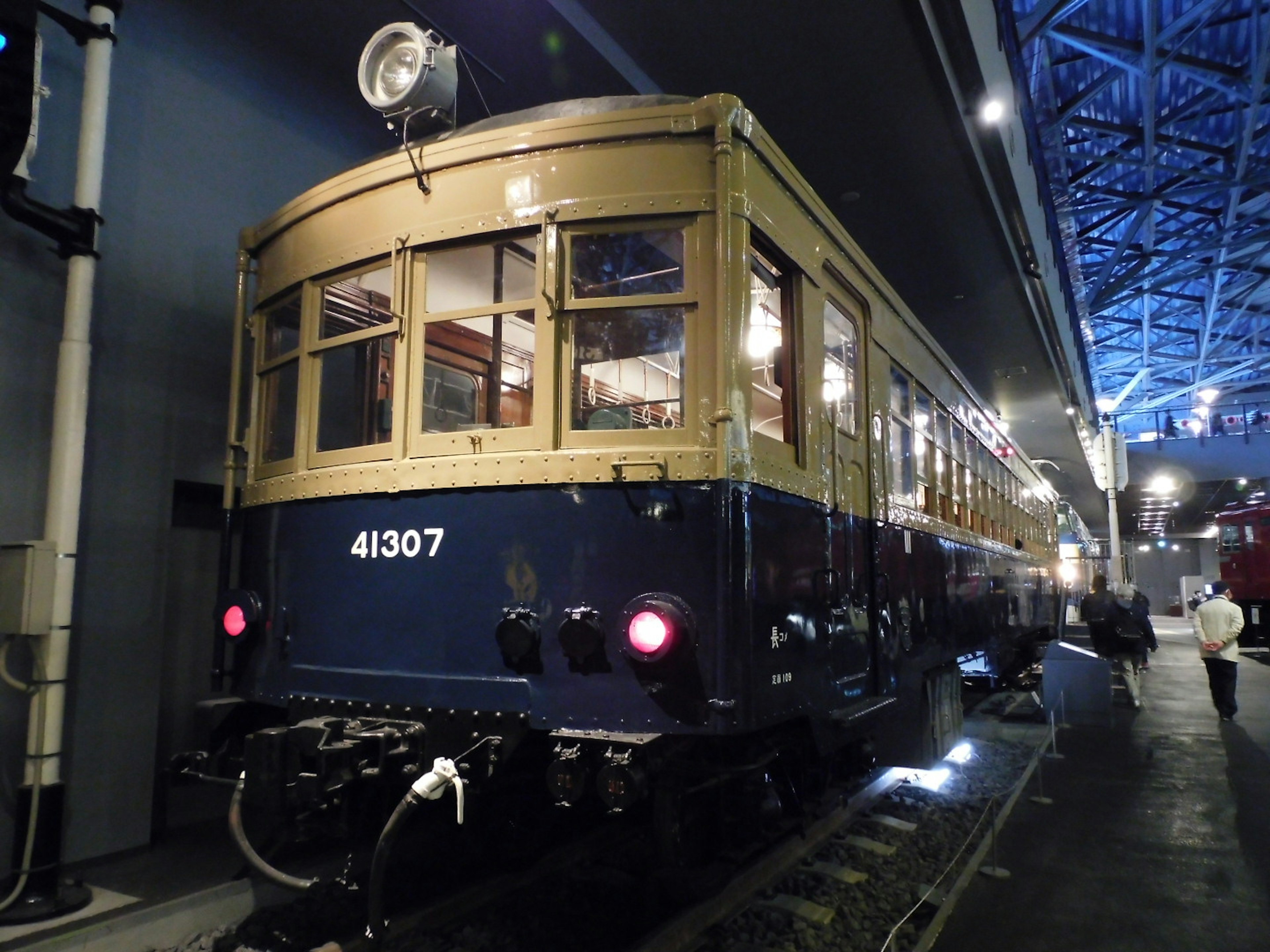 Photo of the rear side of a vintage train in an indoor exhibition space