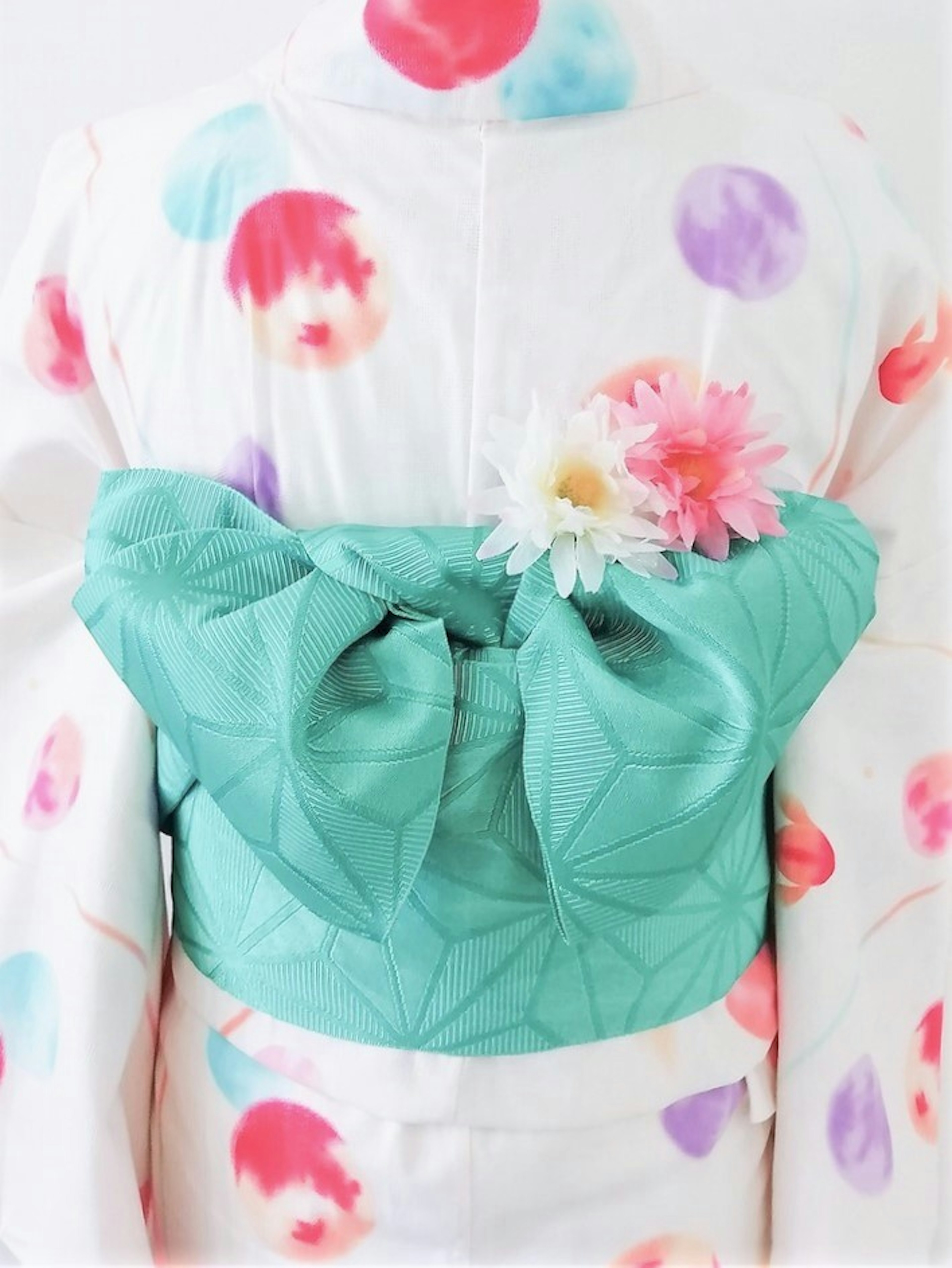 Back view of a colorful polka dot kimono with a green obi and floral decoration