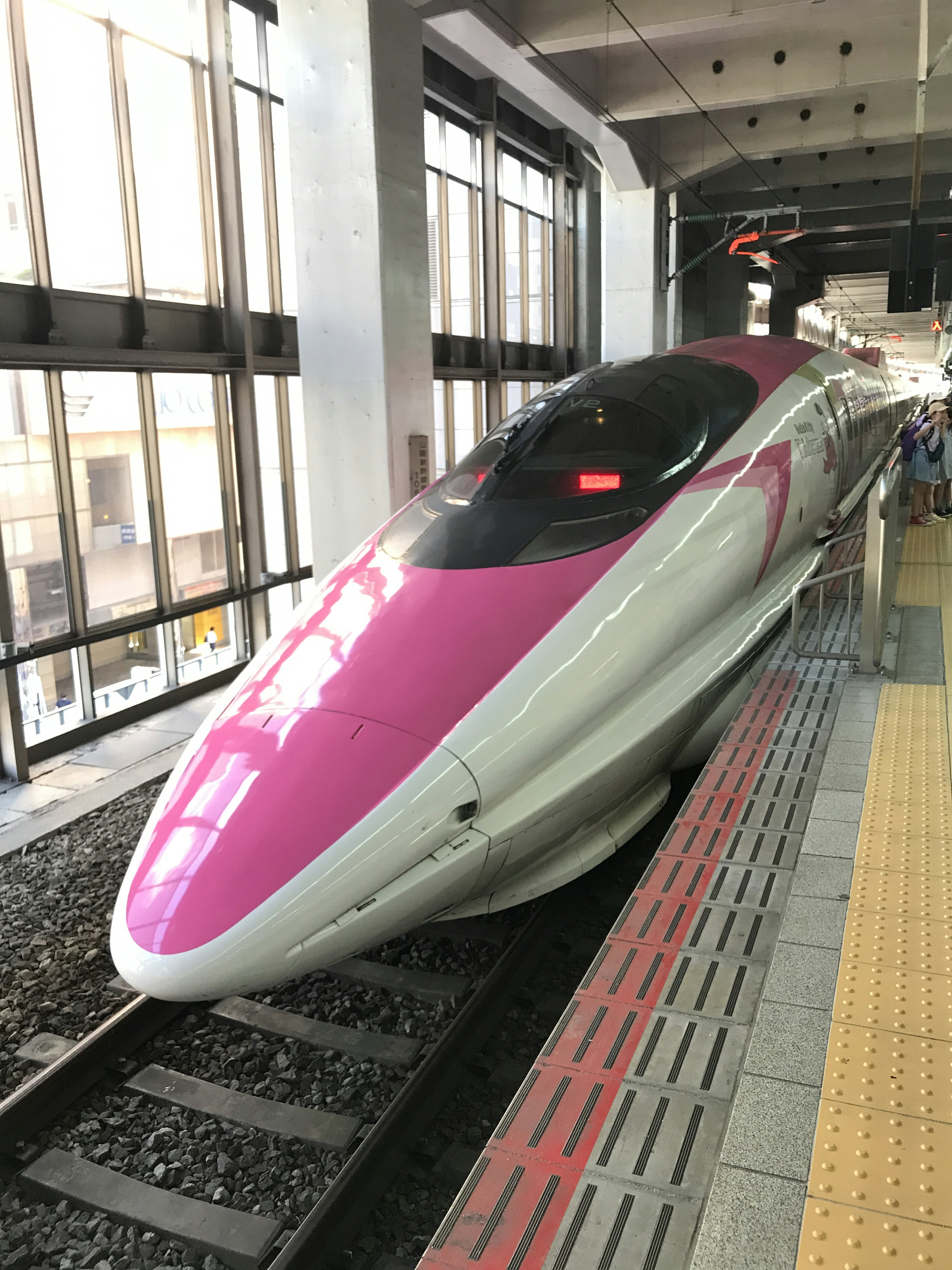 Train Shinkansen avec un design distinctif rose et blanc