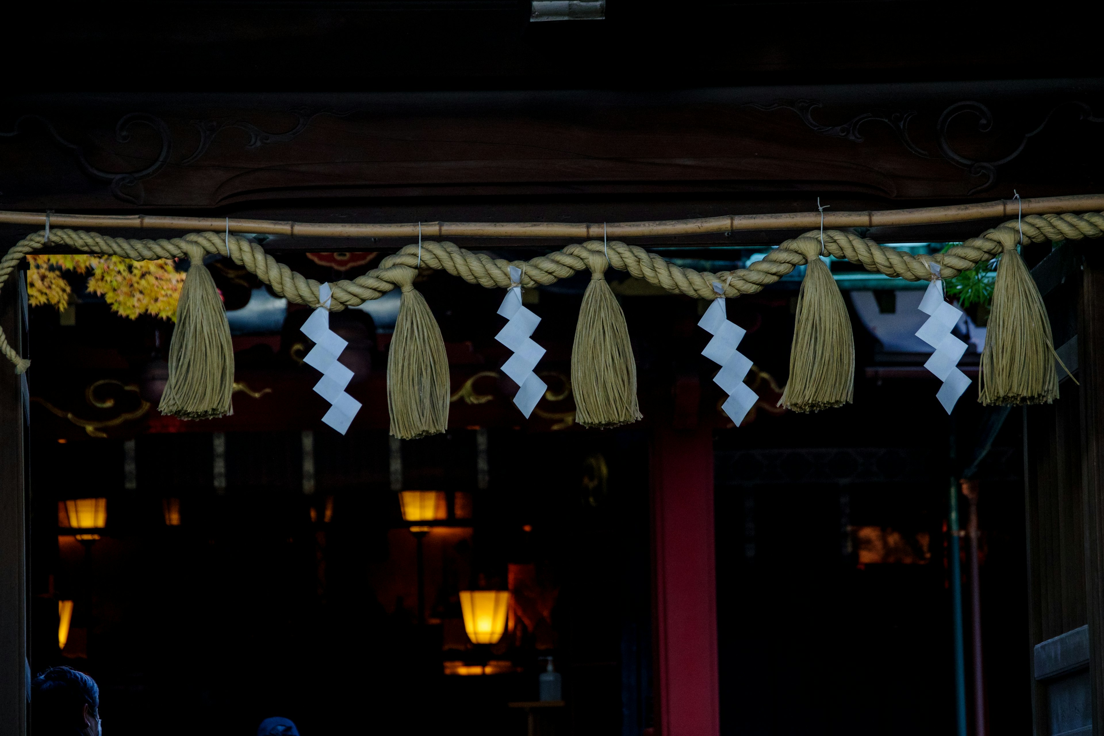 Shinto shrine decoration featuring white and yellow tassels and zigzag paper strips