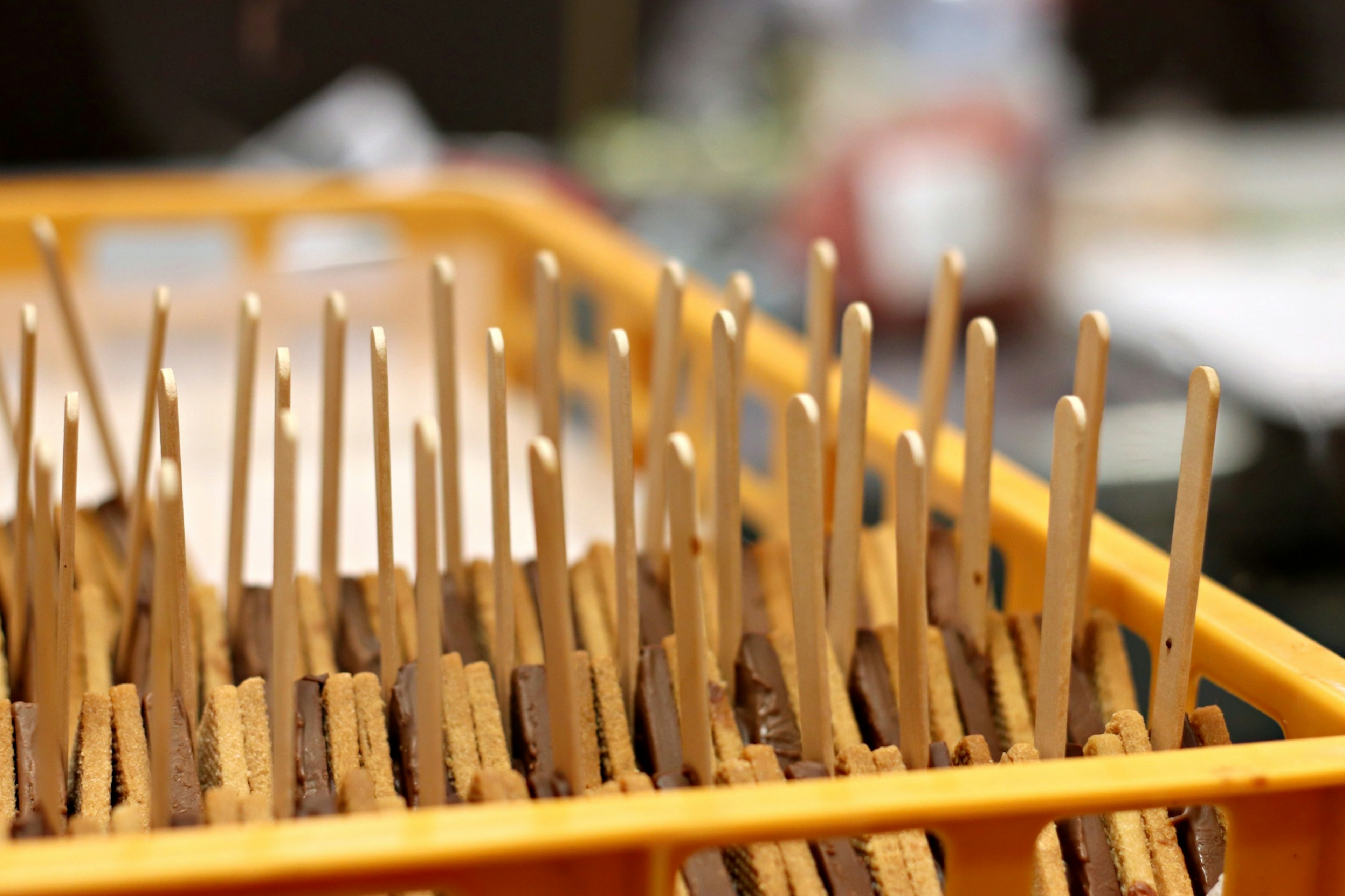 Palitos de madera y galletas dispuestas en una bandeja naranja