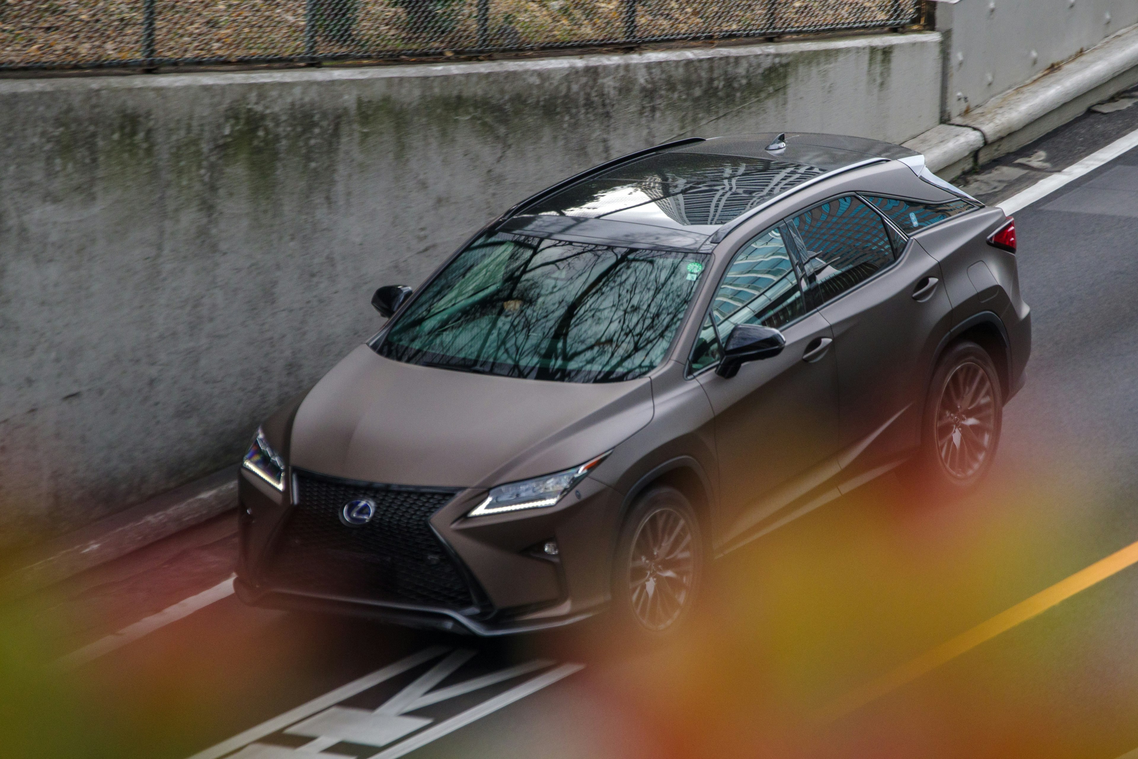 Image of a Lexus SUV parked on the road near a railway