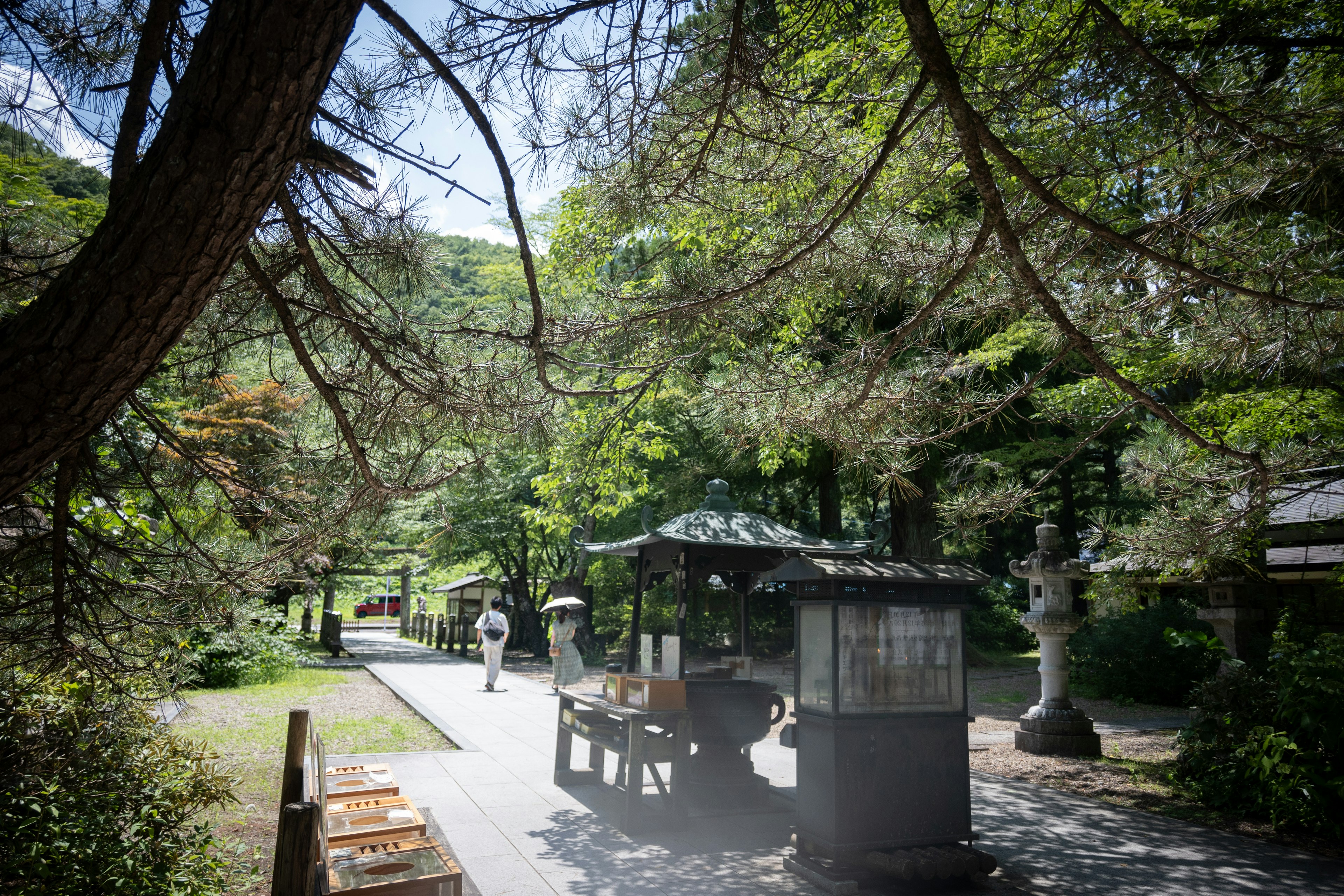 Un sentiero sereno del parco con un chiosco e persone che passeggiano