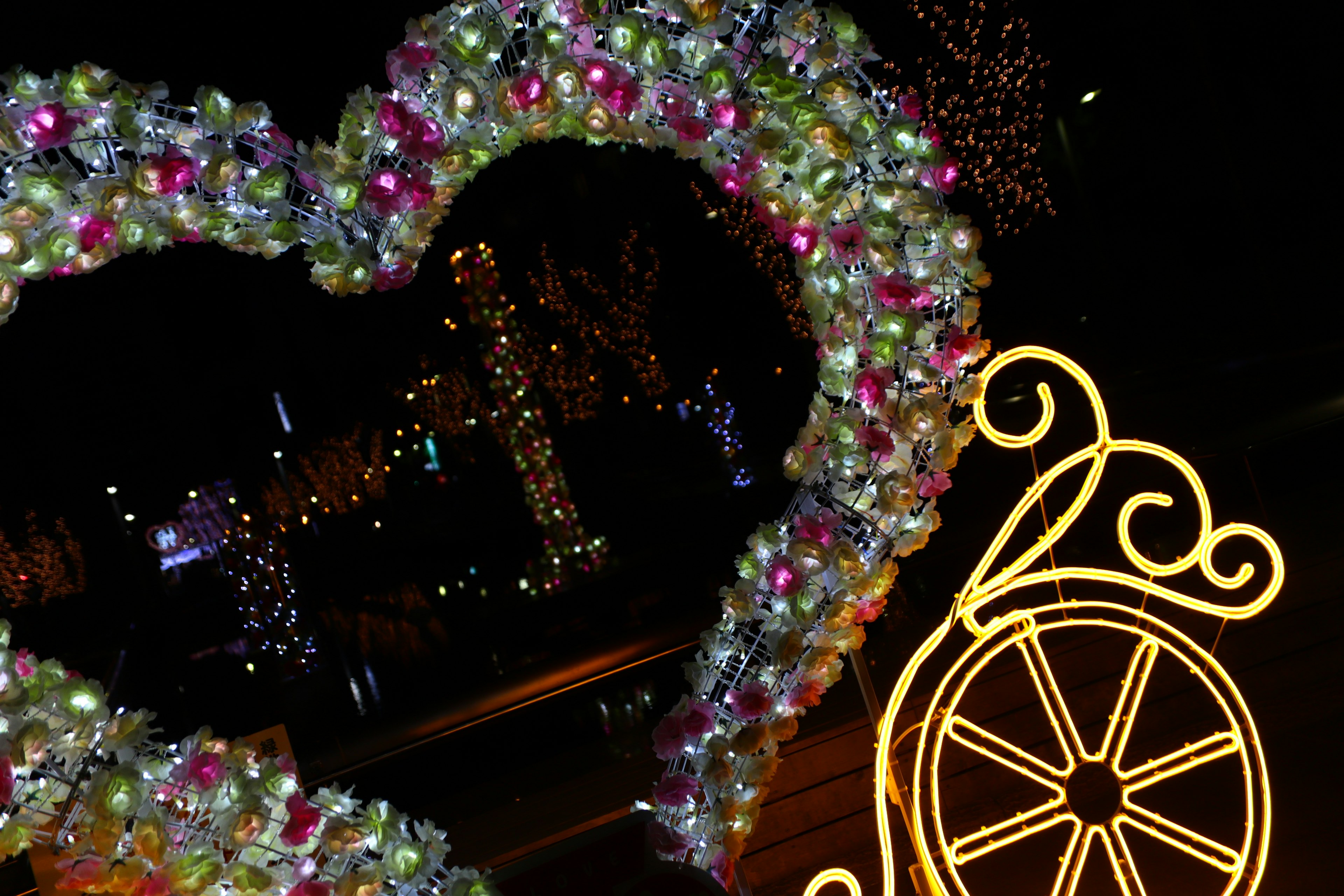 Decoración en forma de corazón colorido con luces en un entorno nocturno