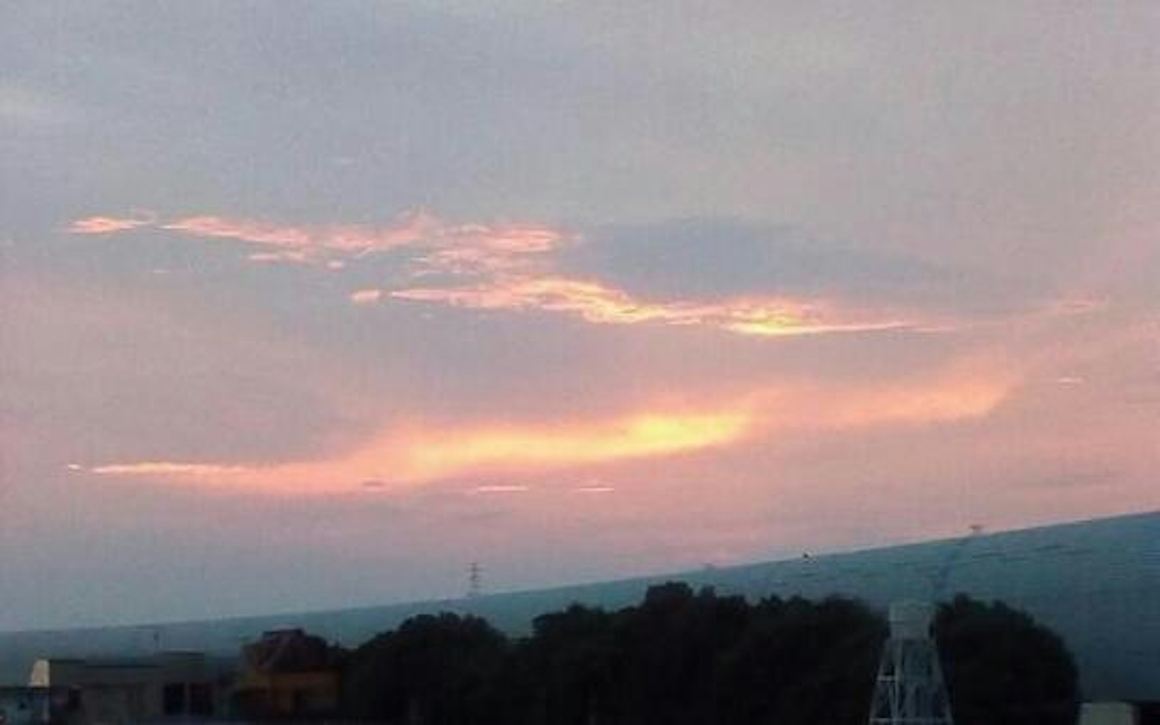 Langit matahari terbenam yang indah dengan awan merah muda dan oranye lembut