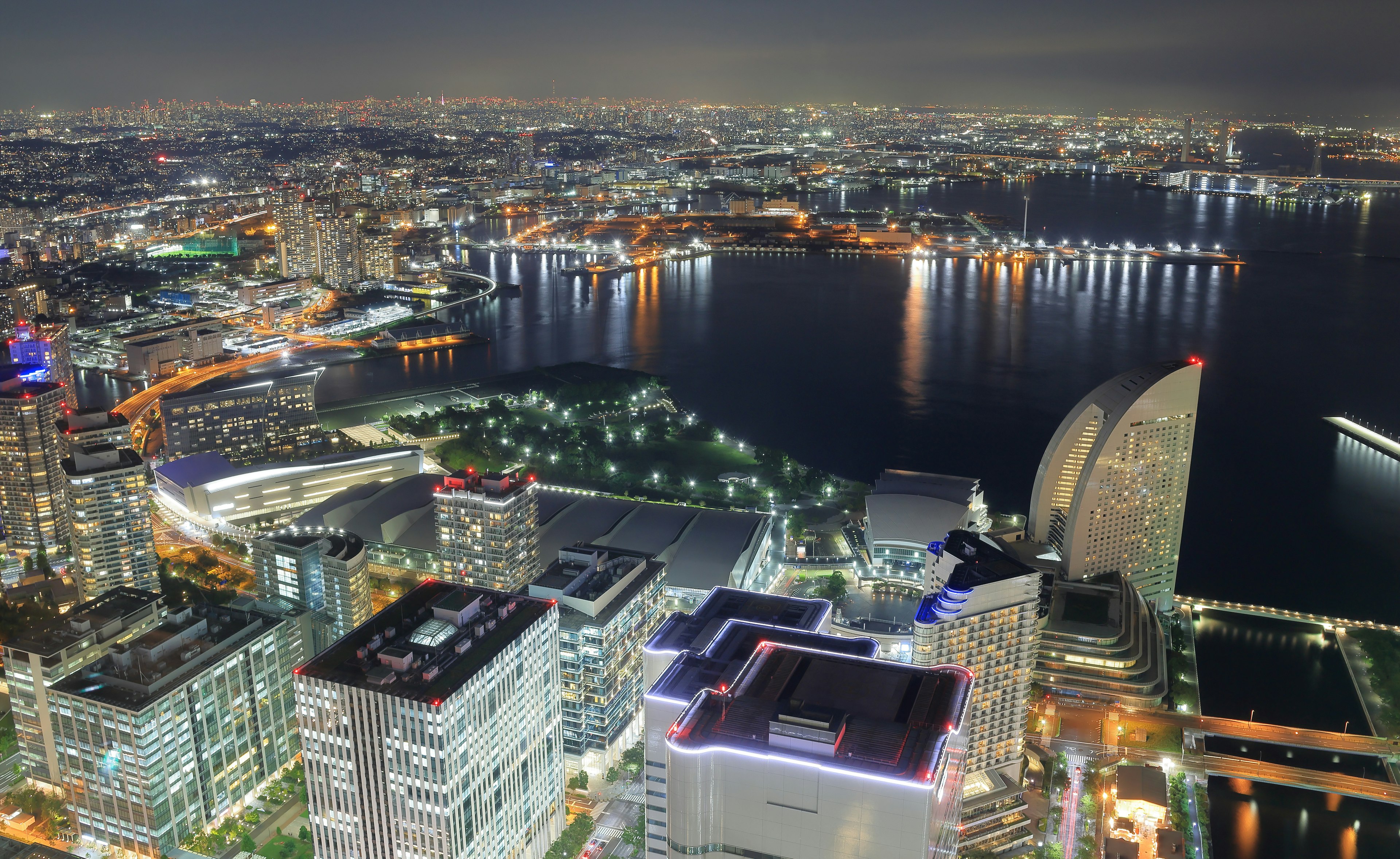 Skyline della città di notte con grattacieli e waterfront illuminato dalle luci della città