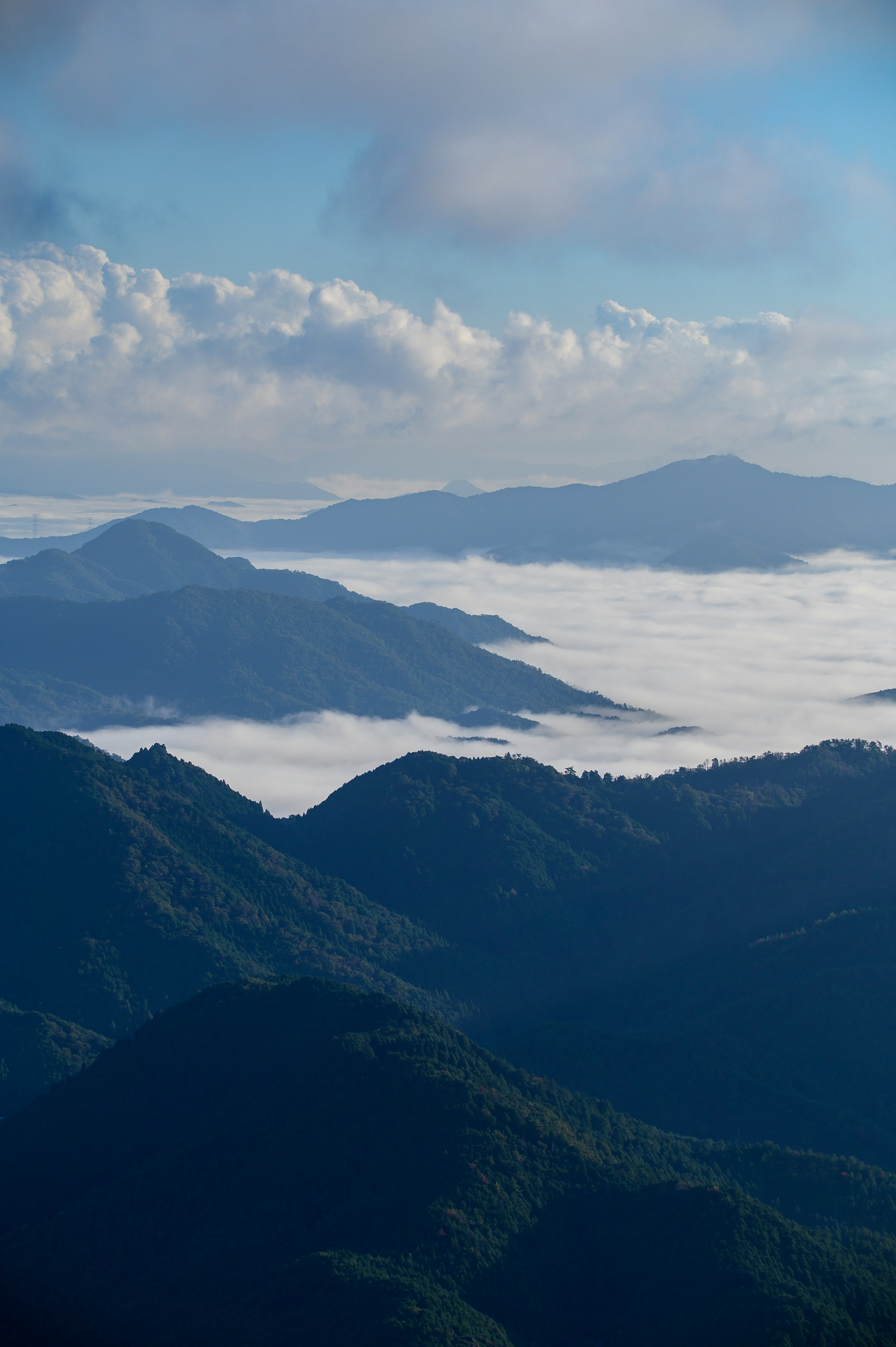 青い空と雲に覆われた山々の風景