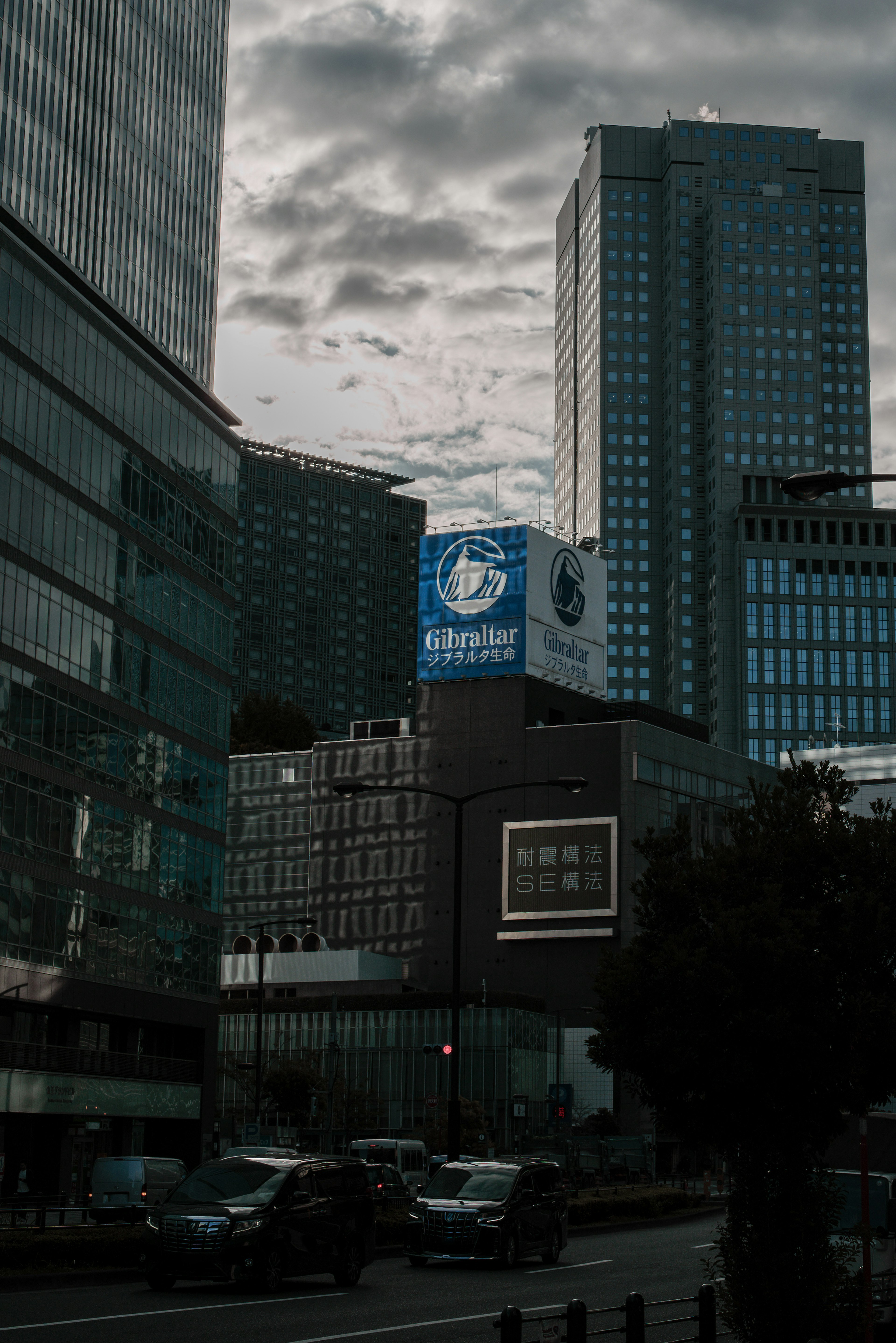 Papan iklan di bawah langit abu-abu dikelilingi gedung pencakar langit