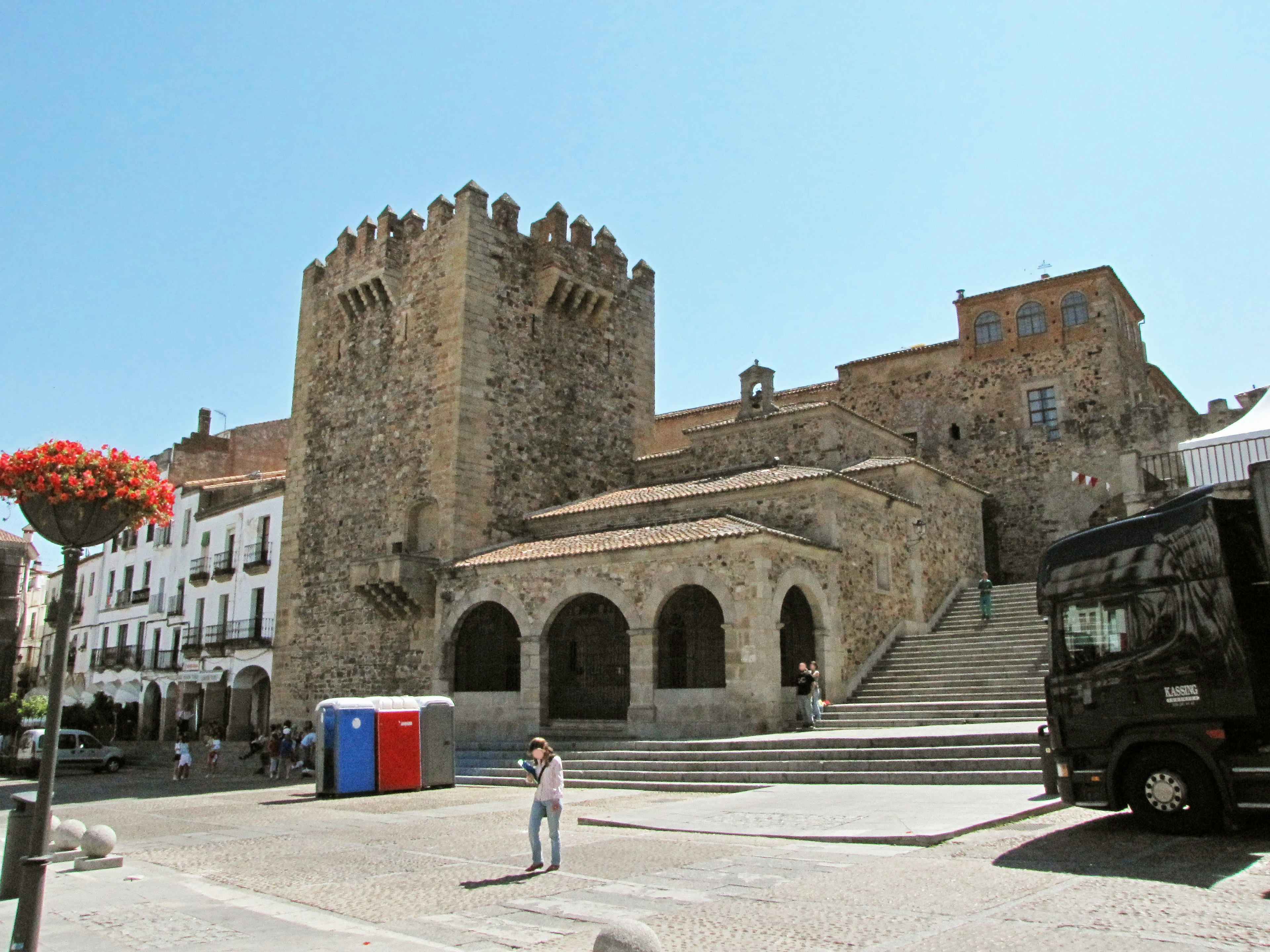 Historic stone building with a tower in a town square