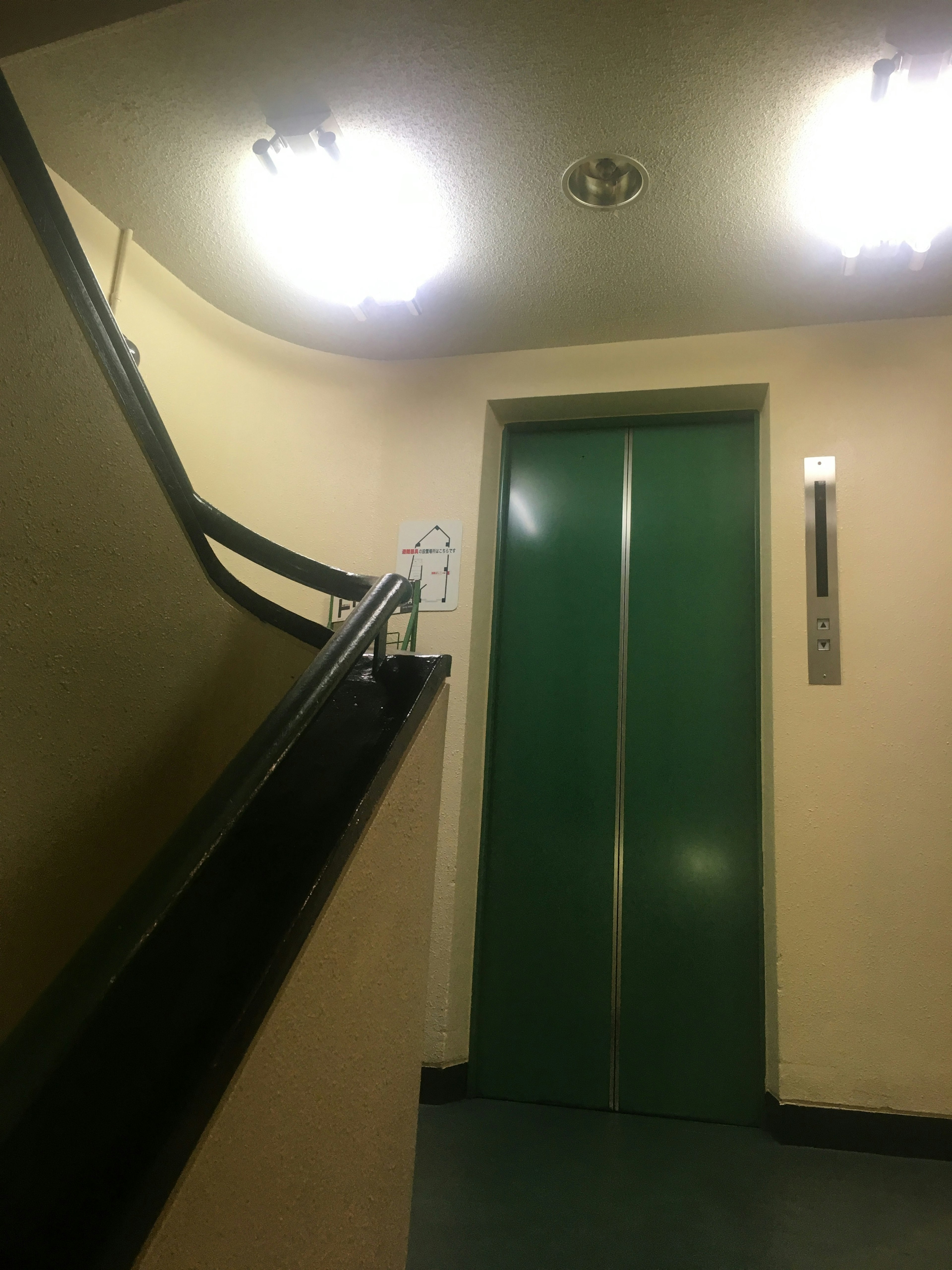 Interior view featuring a green elevator and a curved staircase