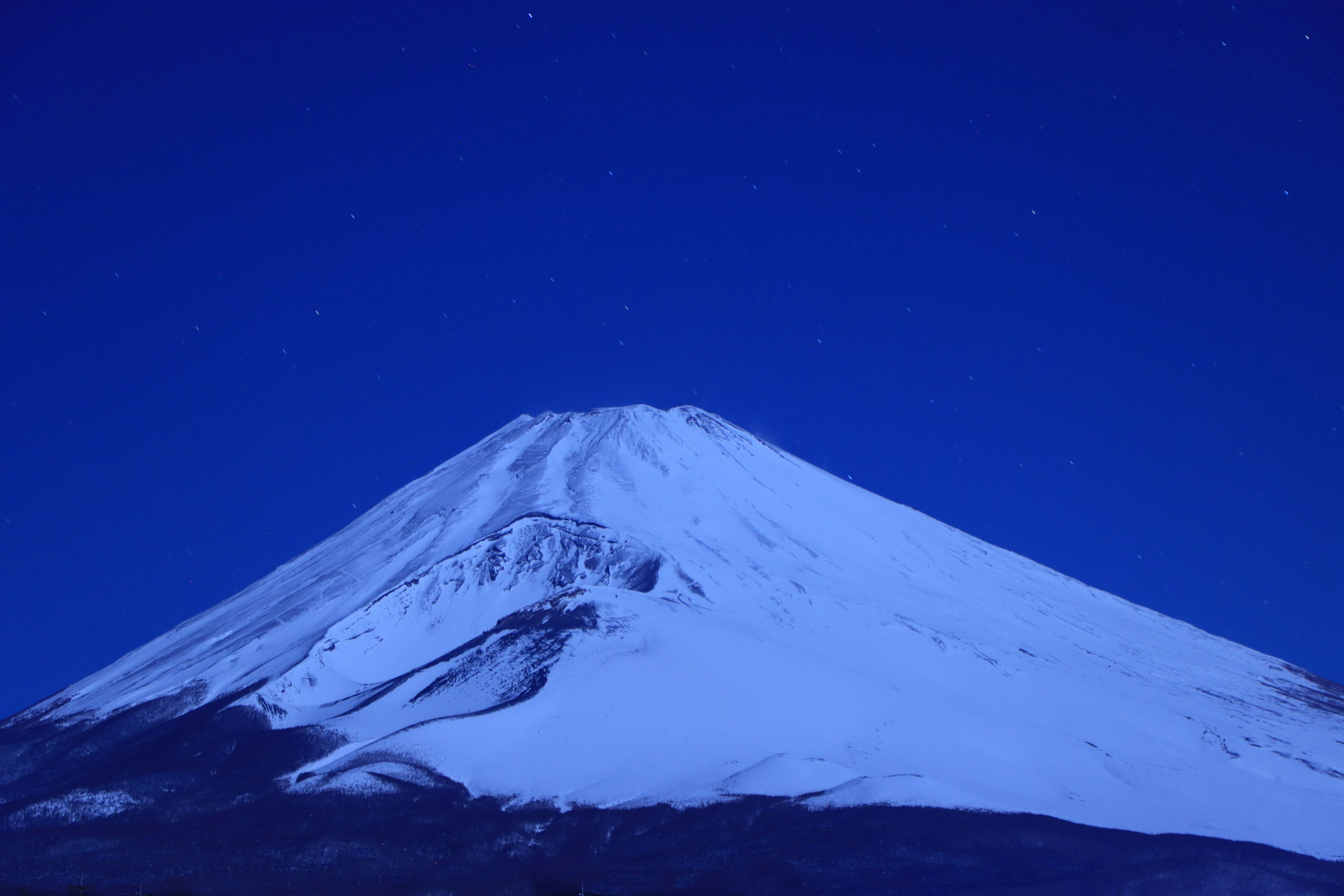 Schöne Aussicht auf den schneebedeckten Fuji unter dem Nachthimmel