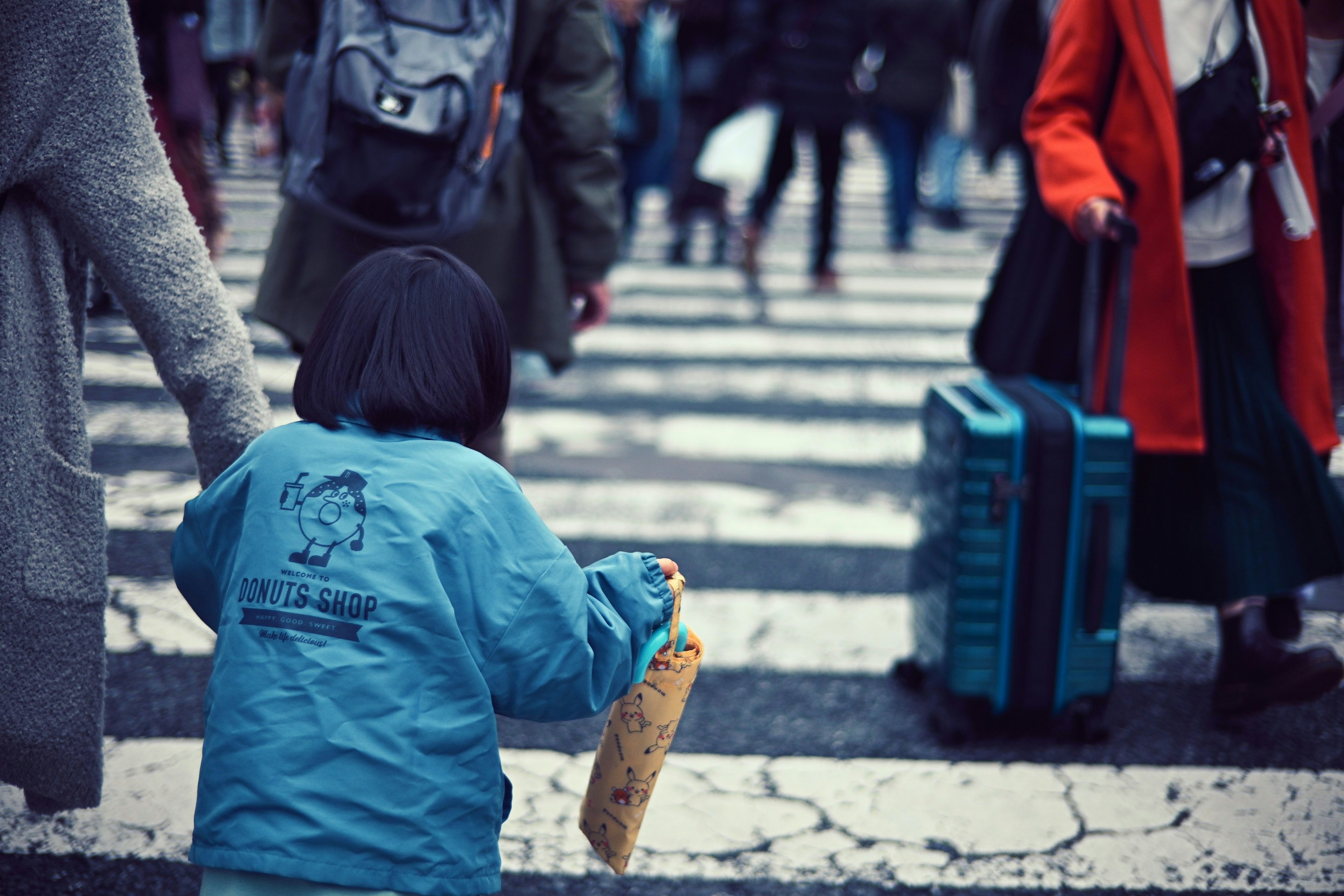 Bambino che attraversa la strada con una folla di persone