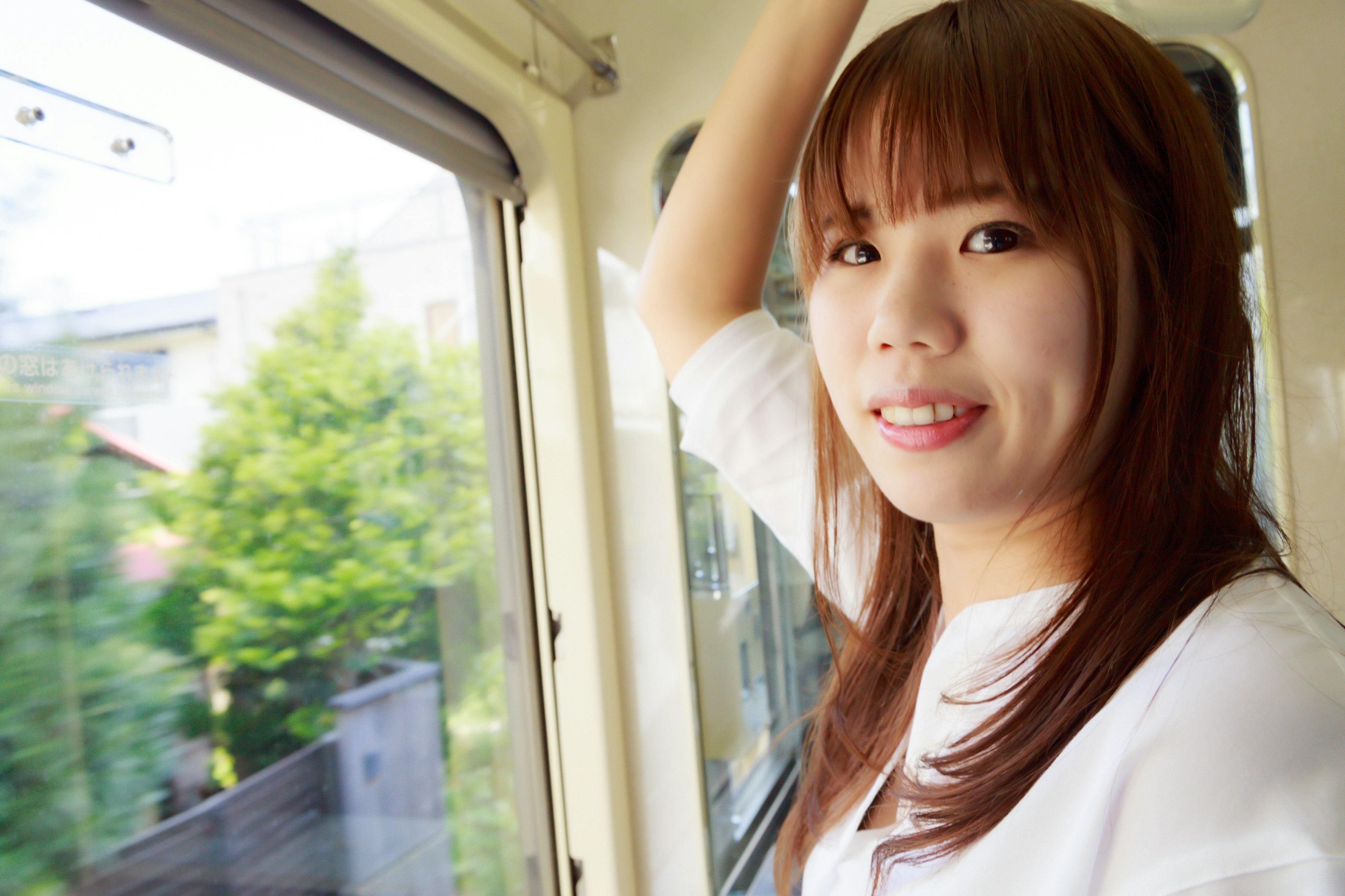 Mujer sonriente mirando por la ventana de un tren