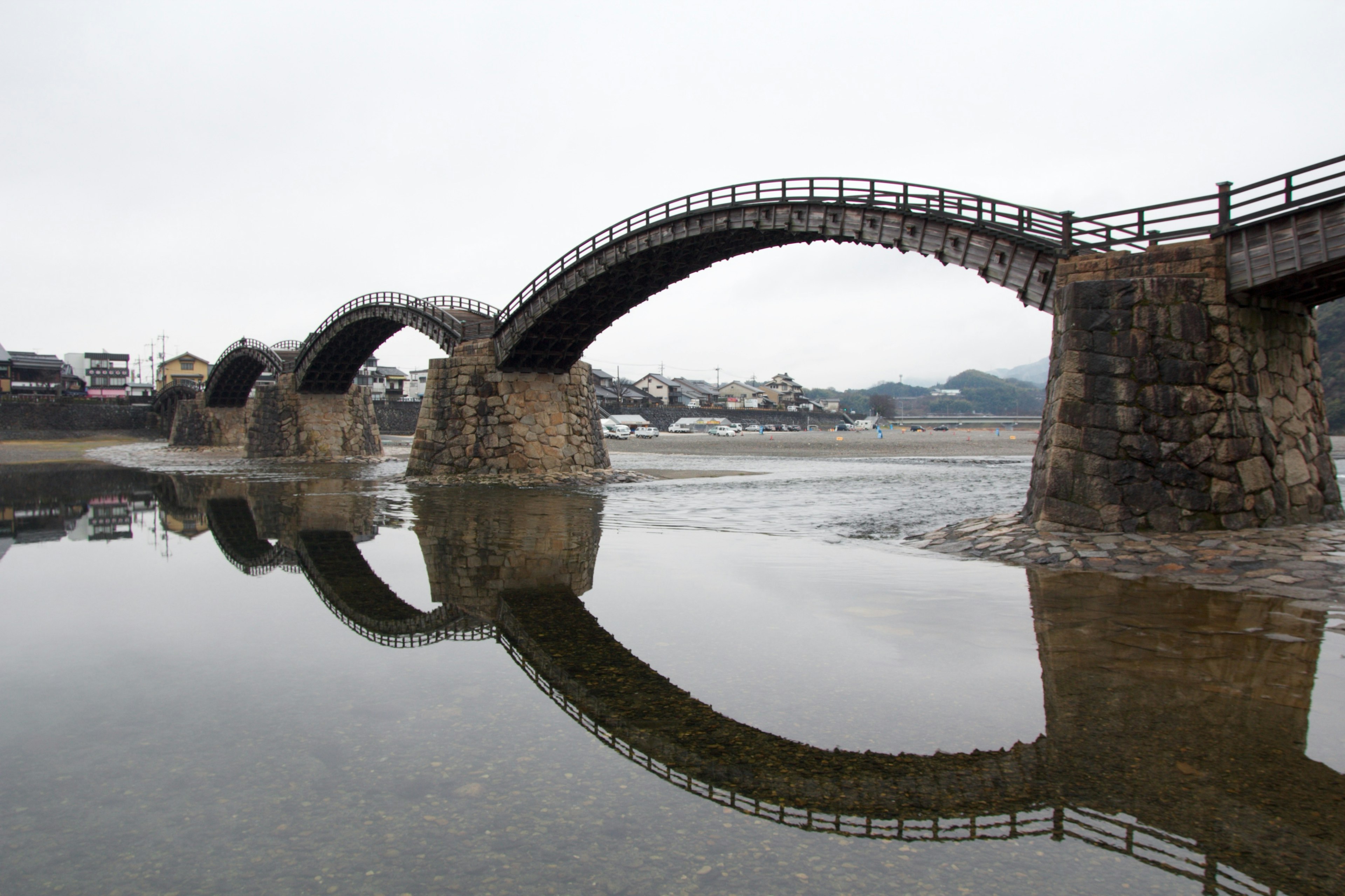 Hermoso puente arqueado reflejado en agua tranquila