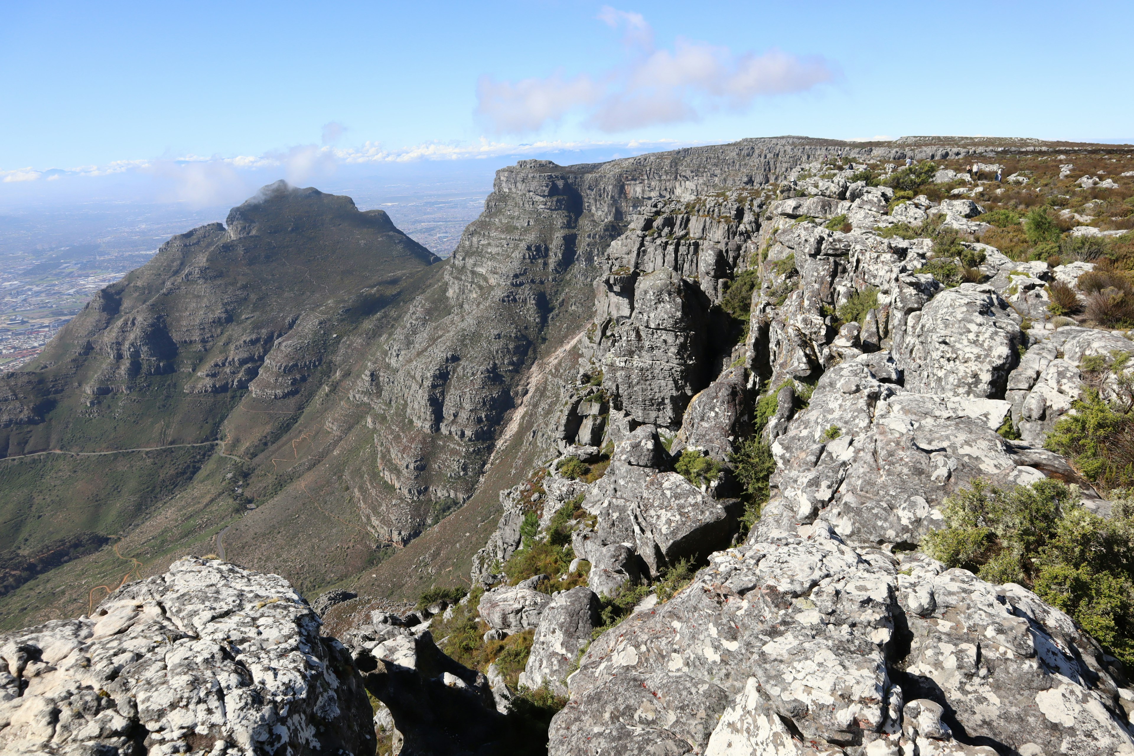 View of rocky cliffs and green hills from Table Mountain