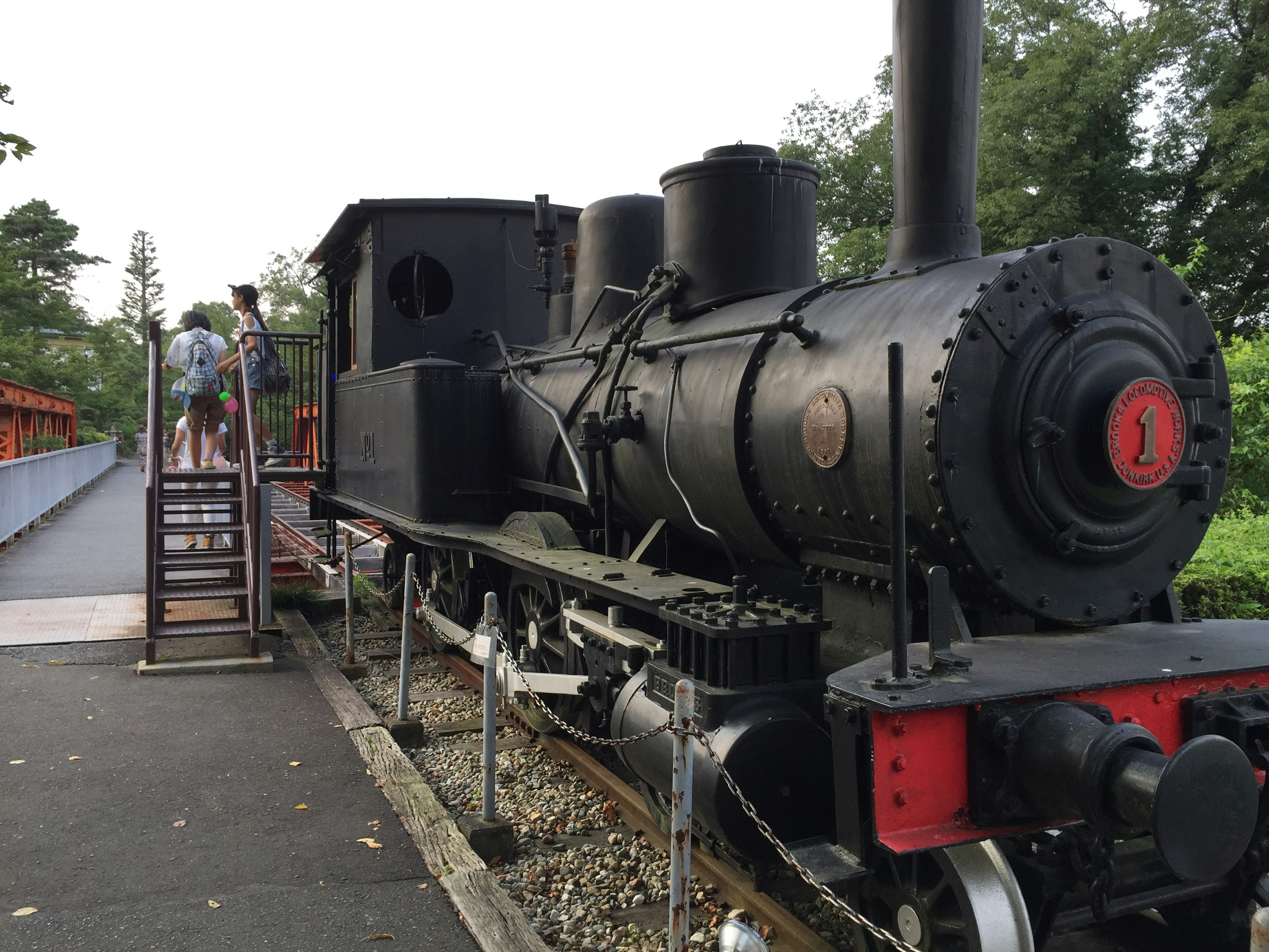 Locomotora de vapor negra con personas cerca