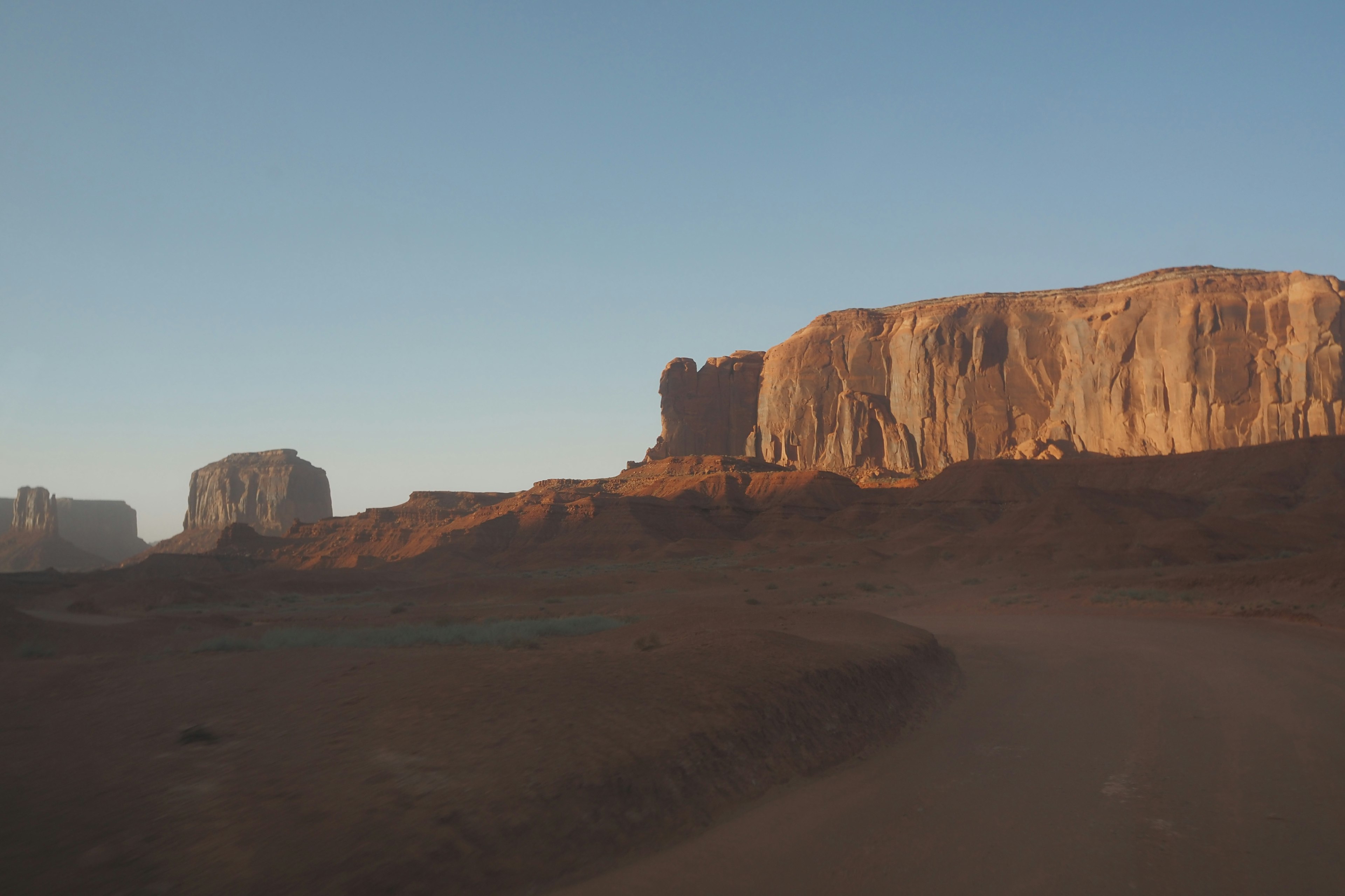 Cảnh quan Monument Valley với các khối đá đỏ và bầu trời xanh