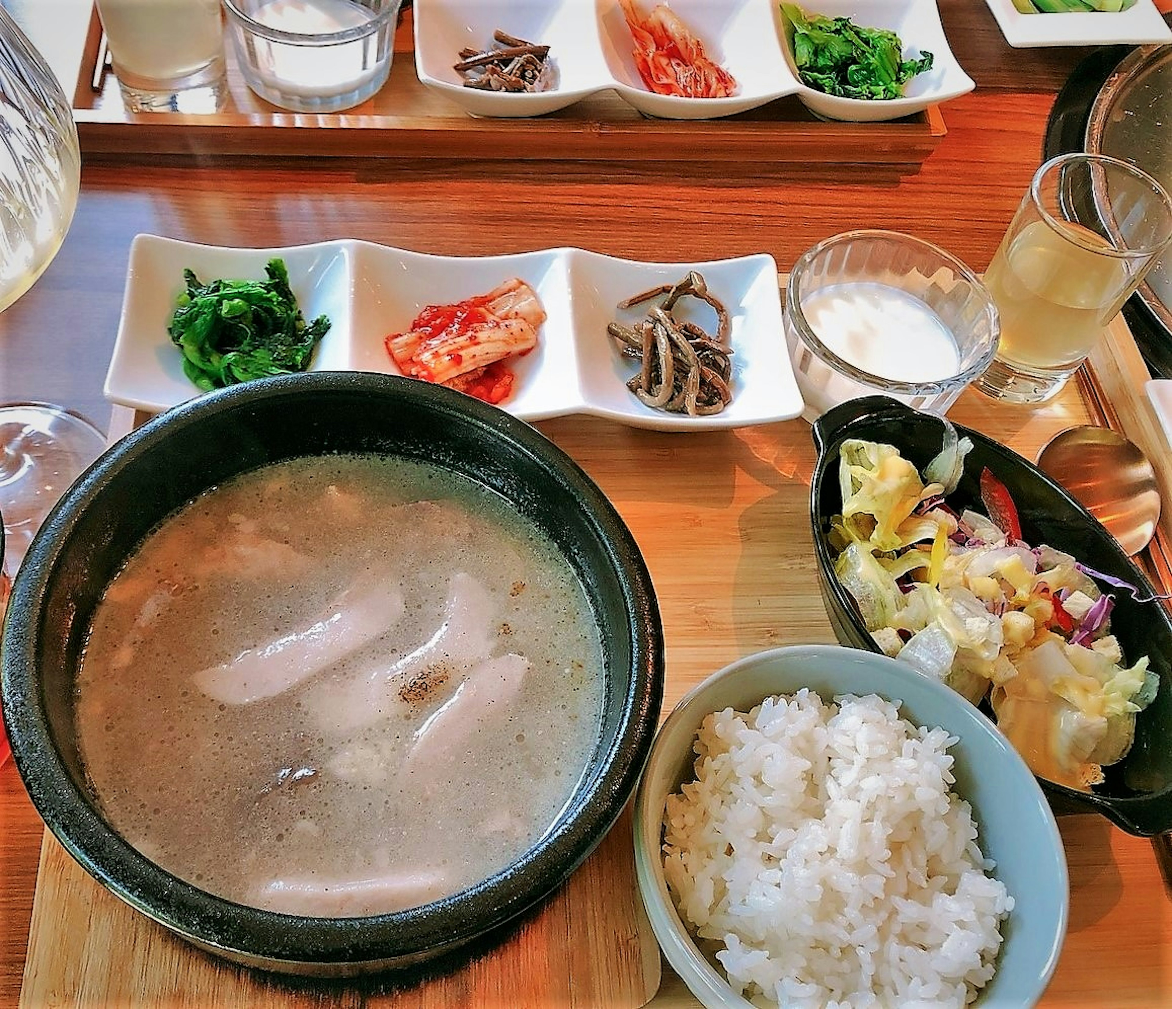 A warm soup bowl with white rice and various small Japanese dishes