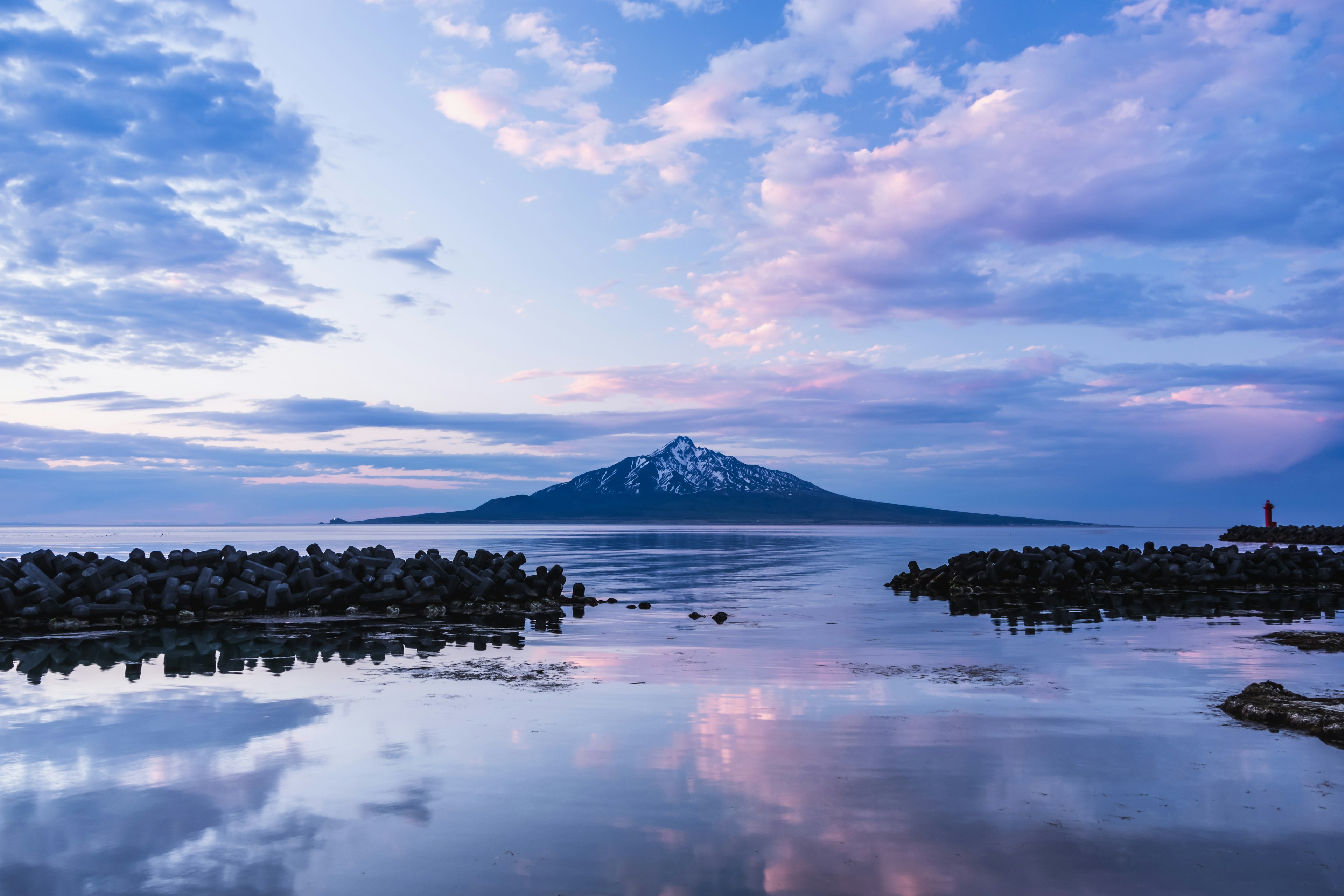 雪をかぶった山と静かな海の風景 薄明かりの空が美しい