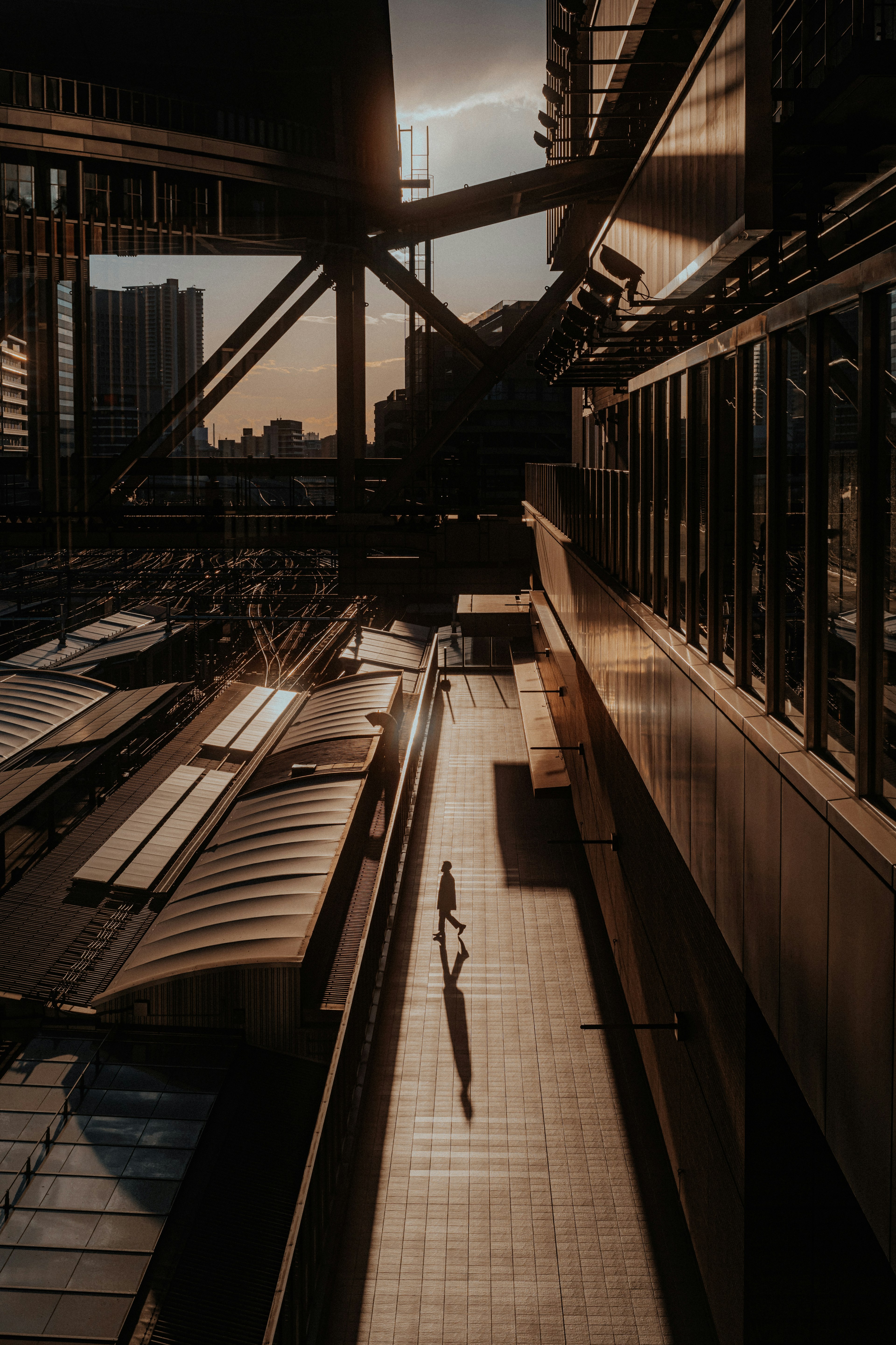 Urban landscape at dusk featuring silhouettes of people between modern buildings