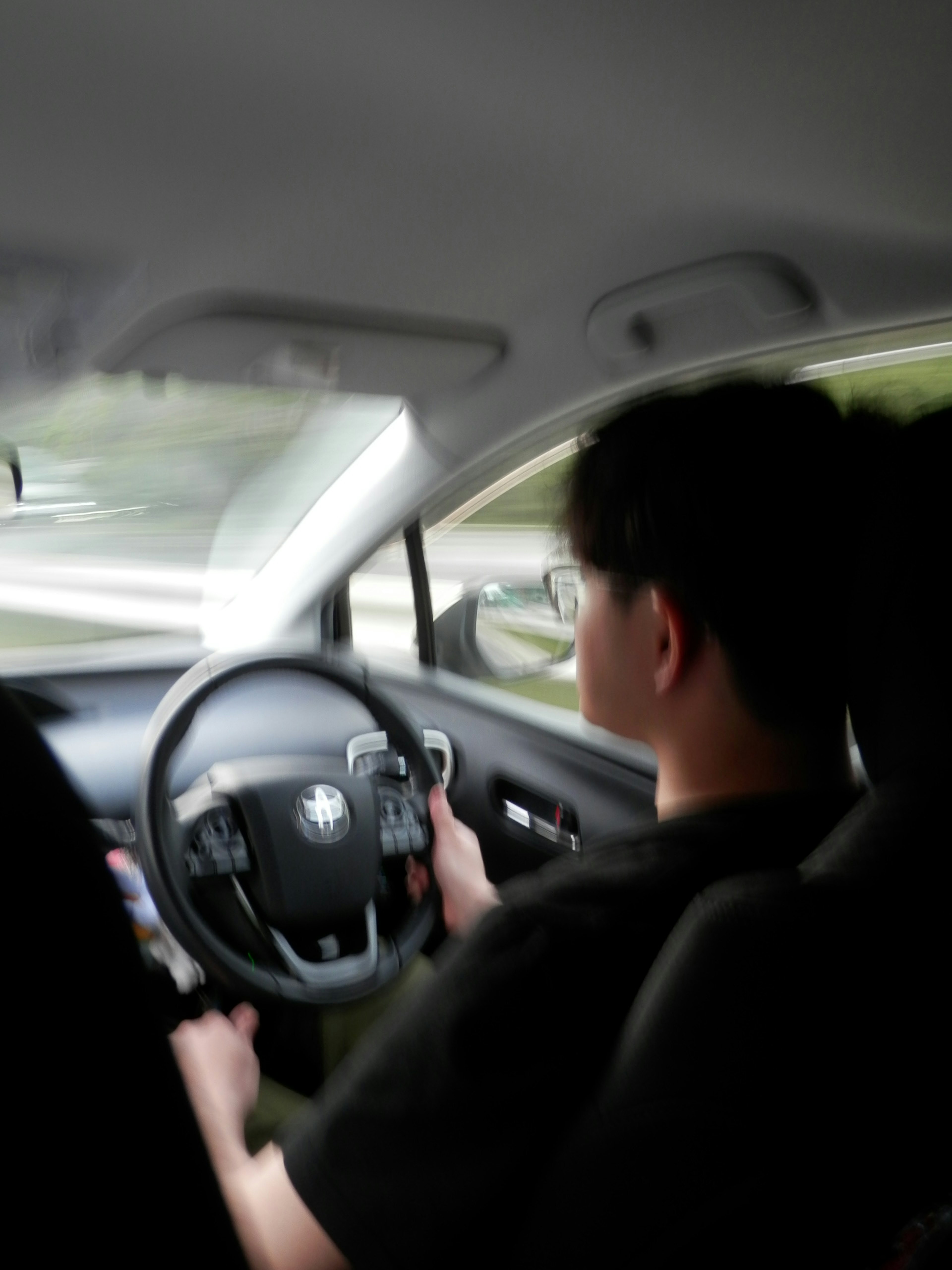 Young man driving a BMW with hands on the steering wheel