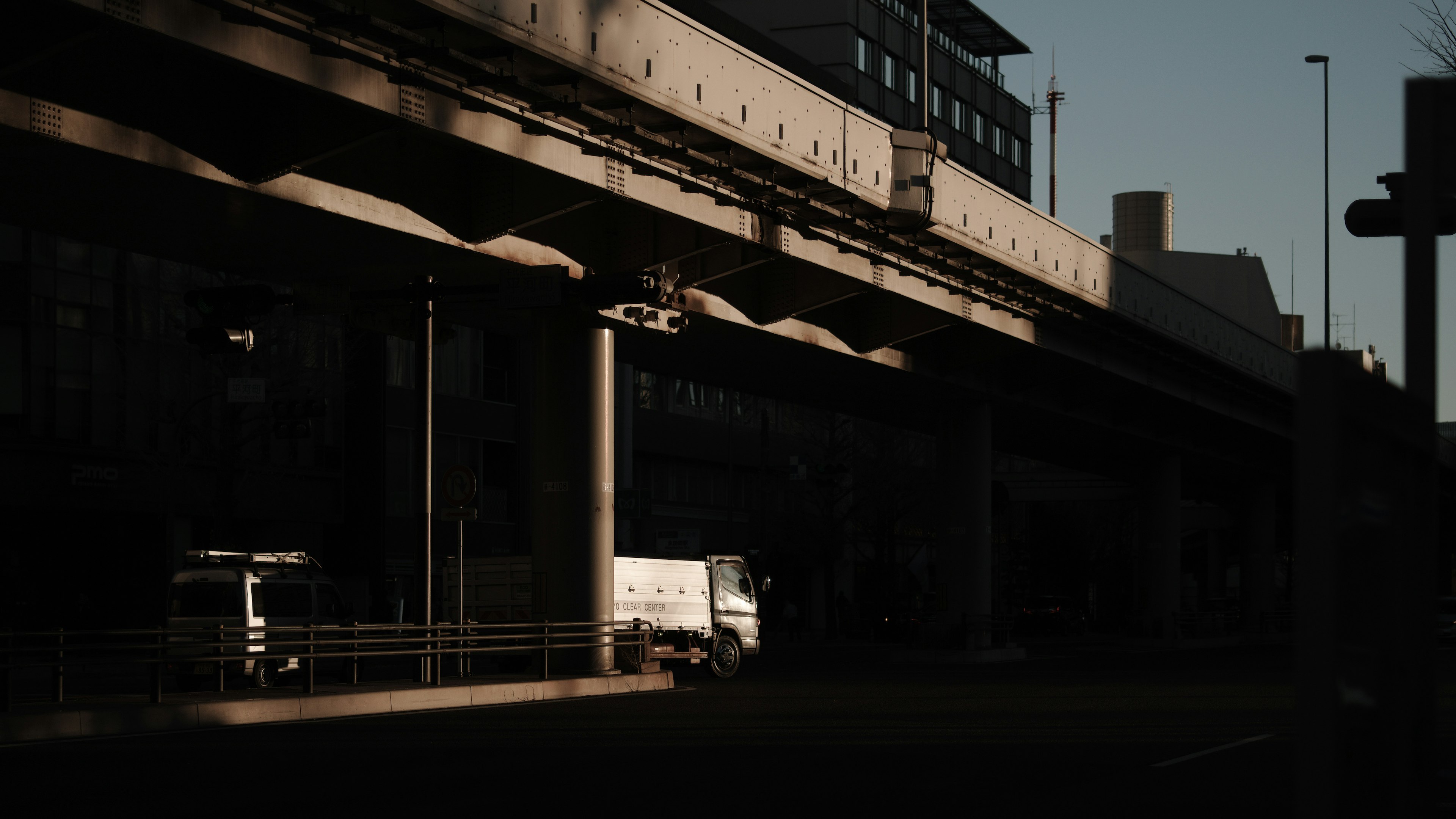 暗い都市の風景にある高架道路とトラック