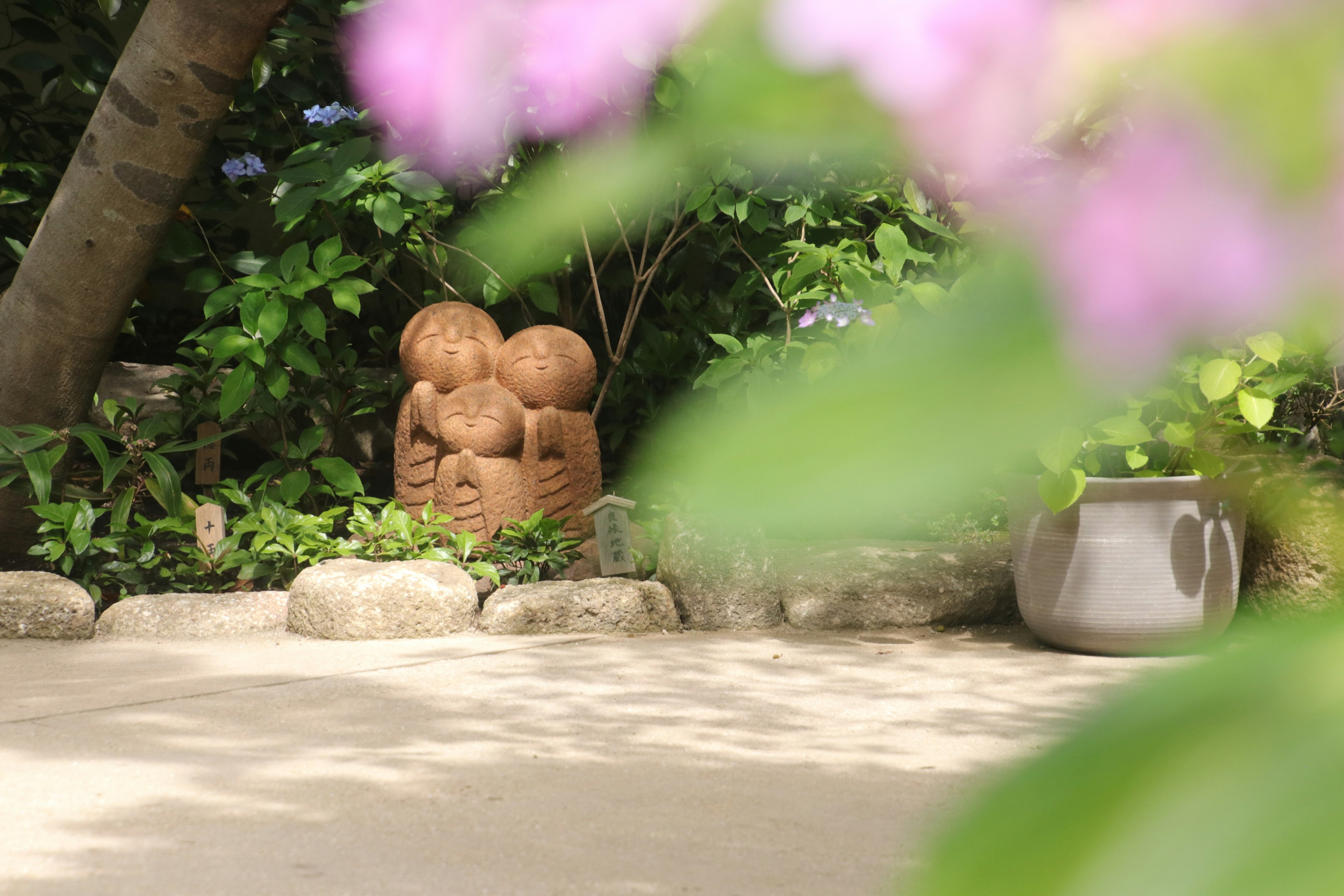 A garden scene featuring a ceramic sculpture surrounded by greenery