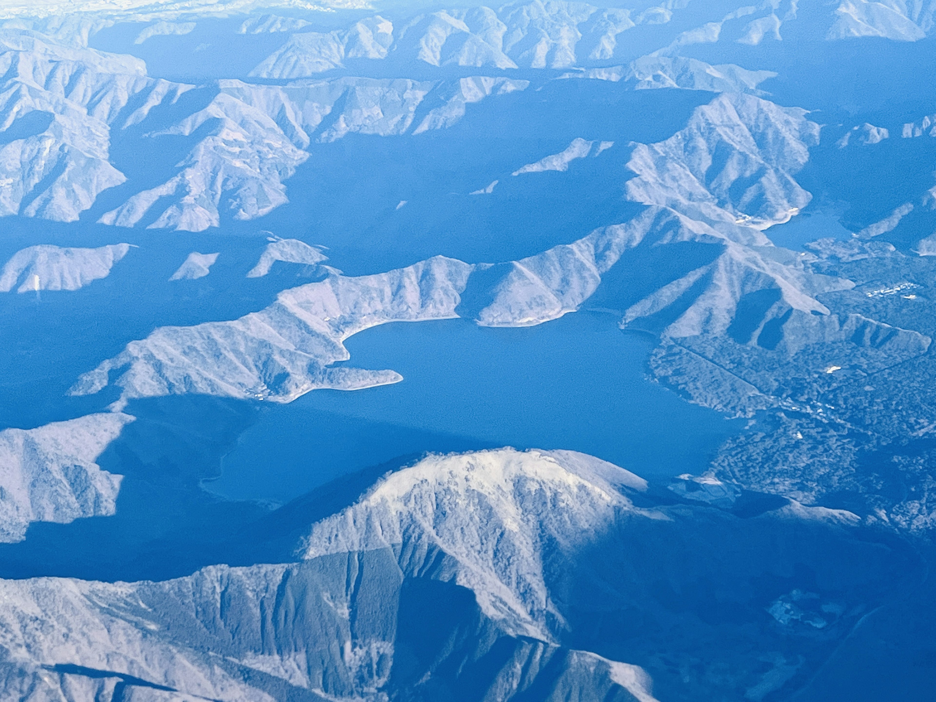 Luftaufnahme von Bergen und einem See in blauen Tönen, die die natürliche Schönheit zeigen