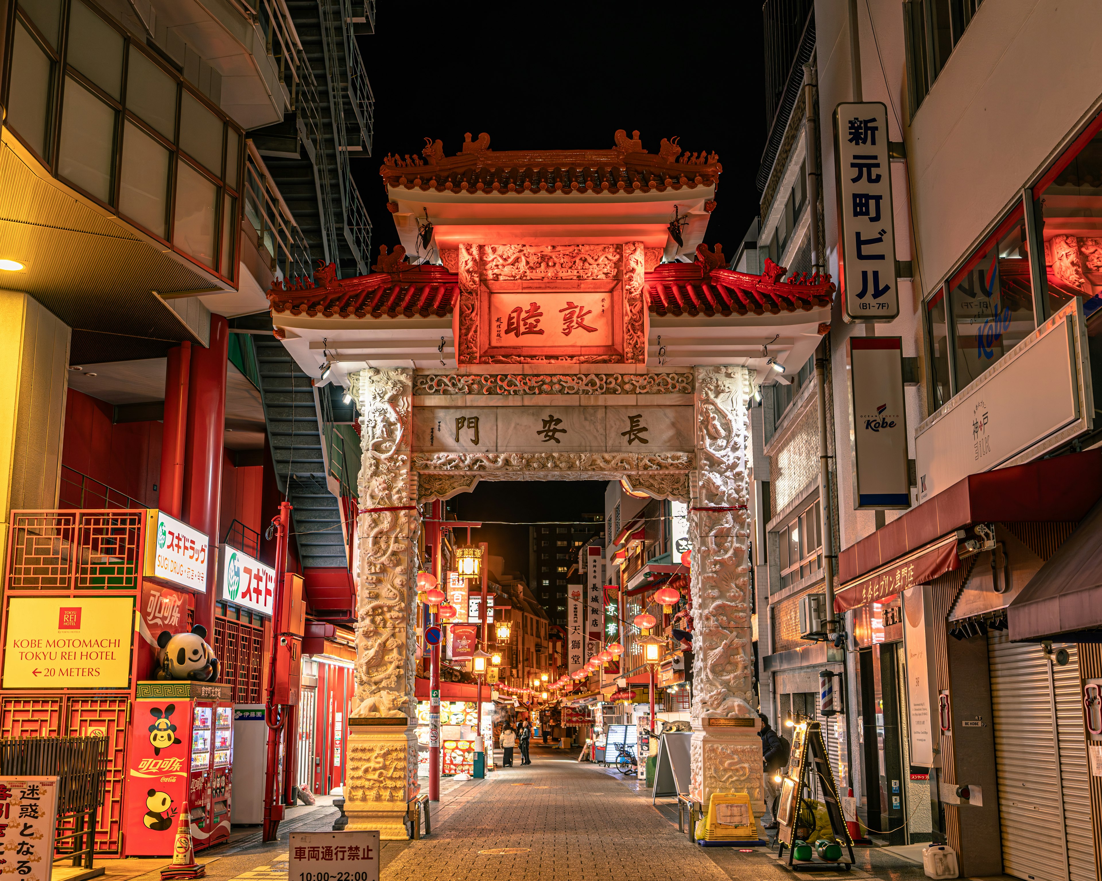 Arco de Chinatown iluminado por la noche con tiendas a lo largo de la calle