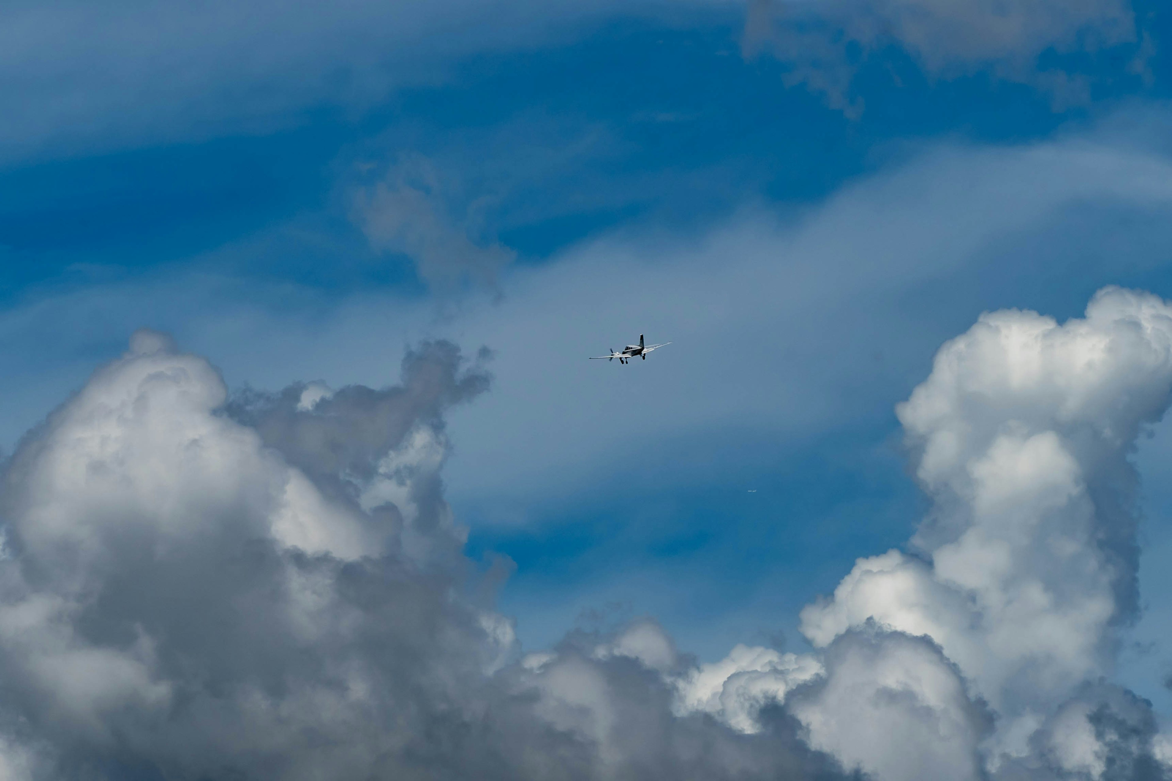 青空に浮かぶ飛行機と白い雲