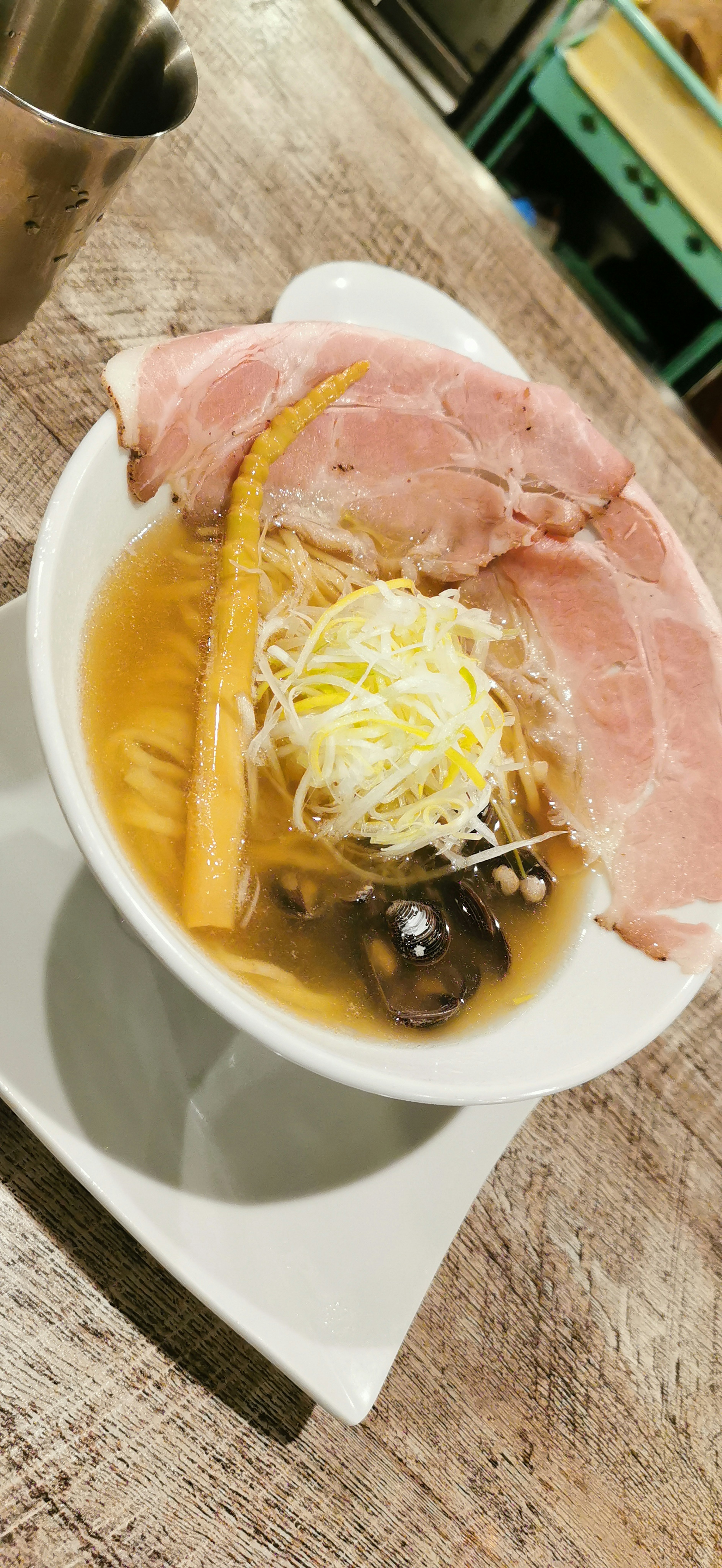 スープにハムとネギがトッピングされたラーメン