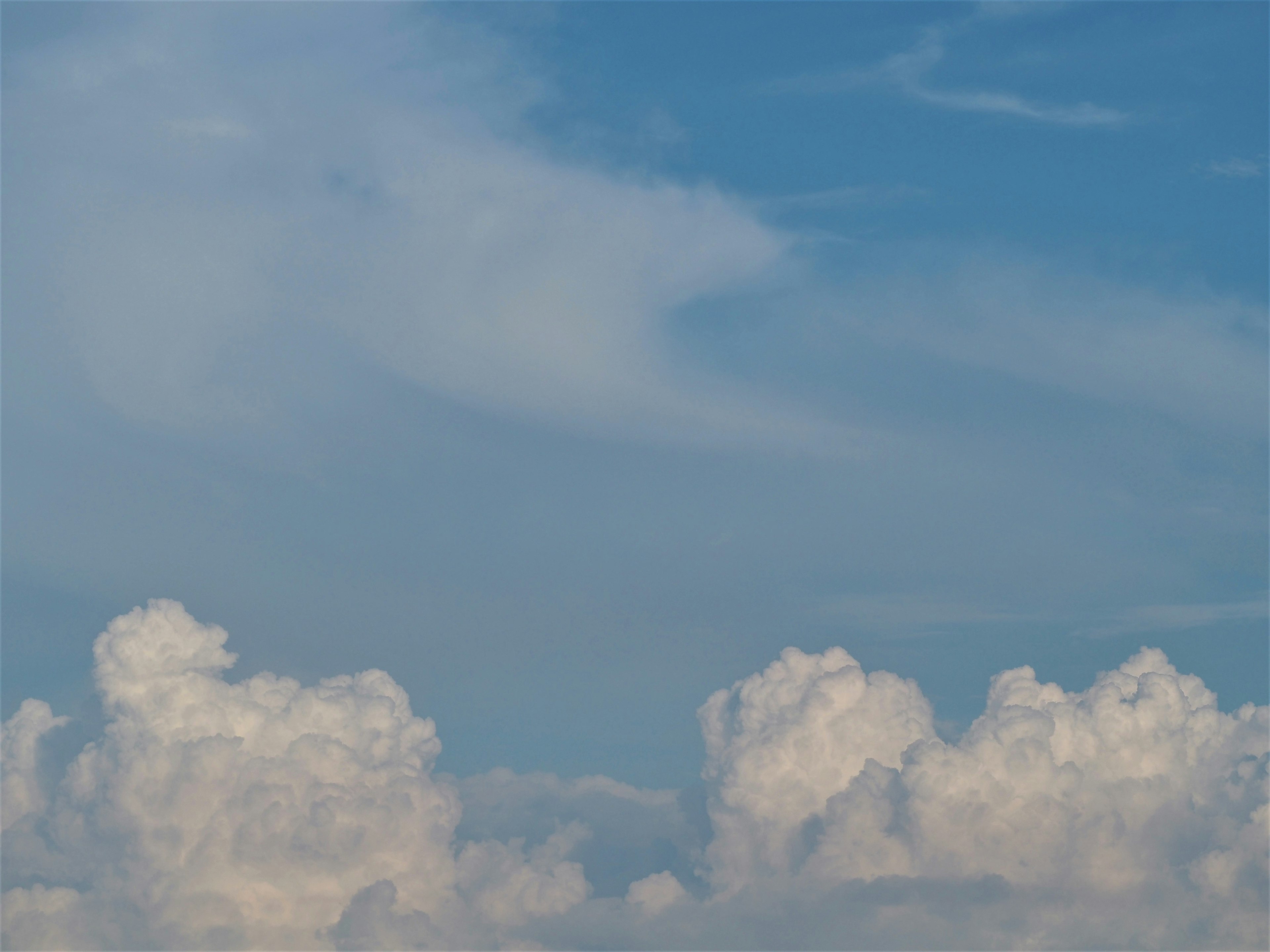 Un paesaggio di nuvole bianche che galleggiano in un cielo blu