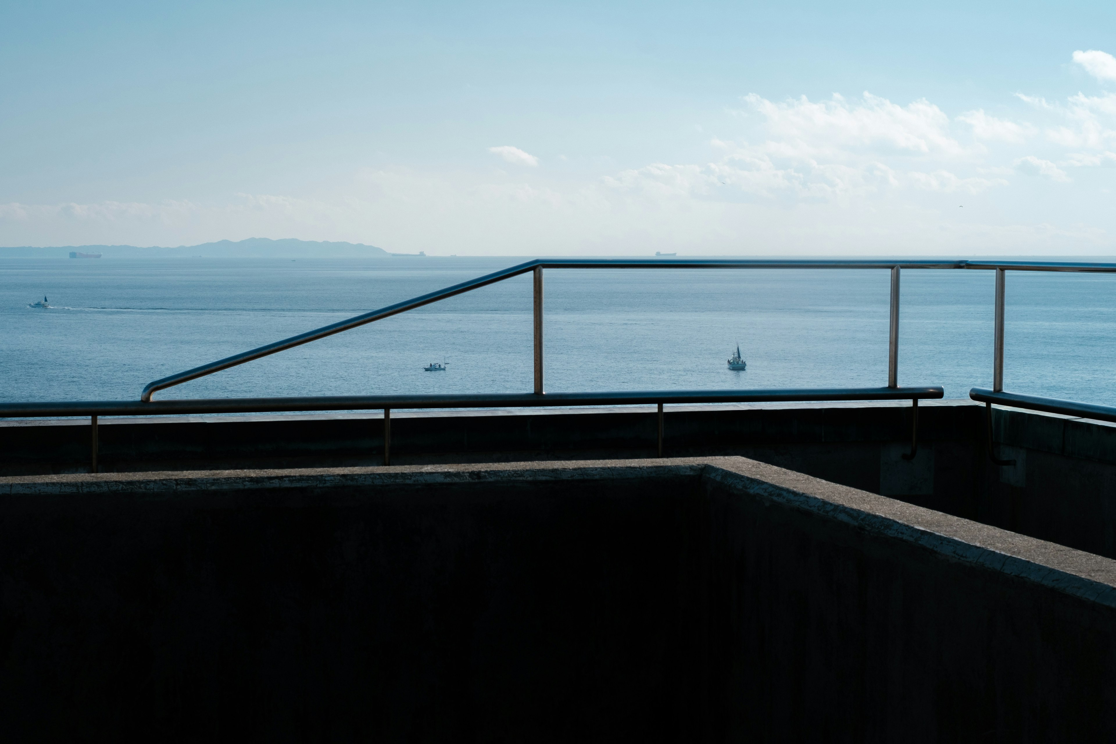 Geländer und Wand eines Balkons mit Blick auf das Meer