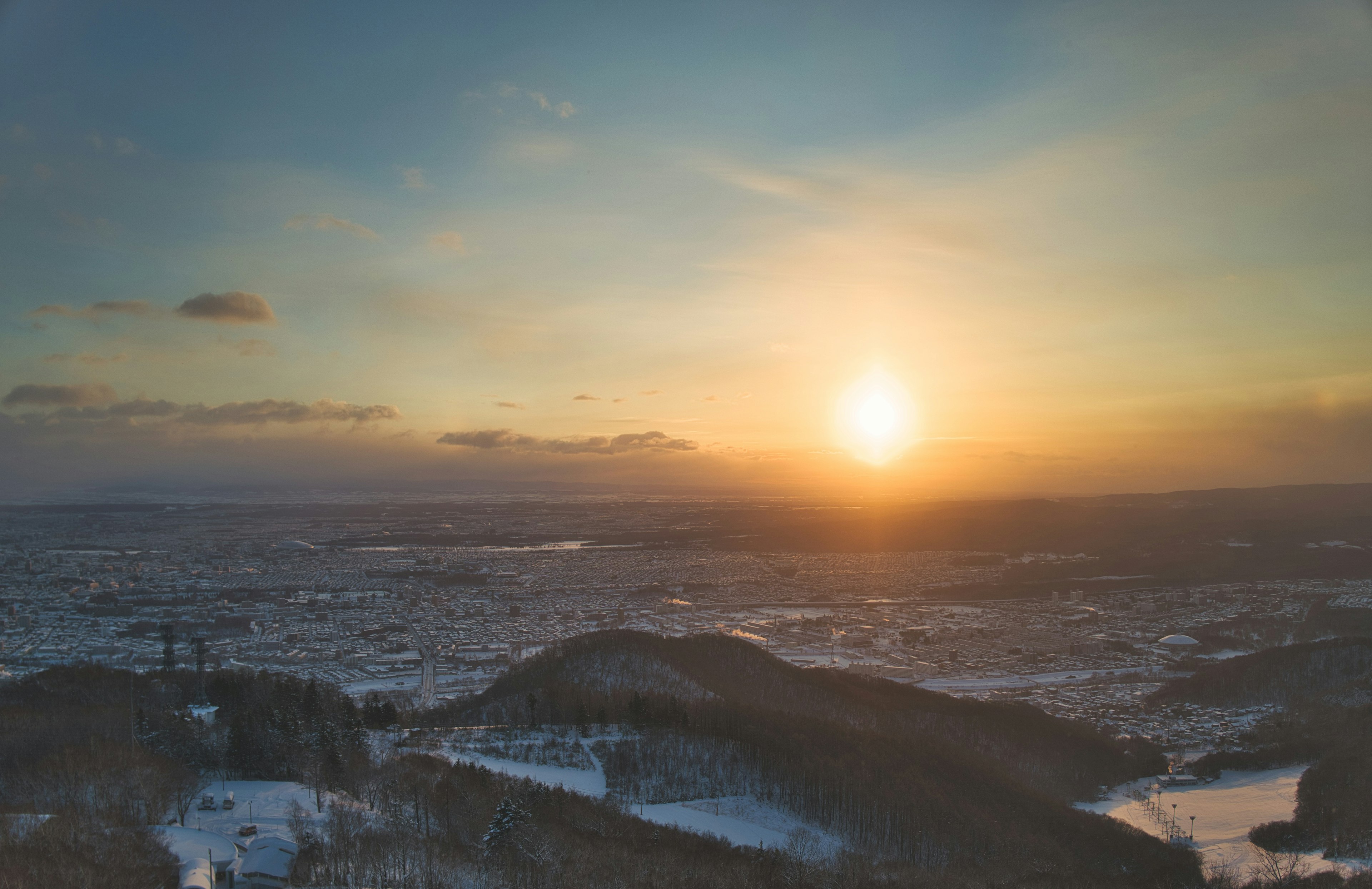 冬の夕日が沈む風景と雪に覆われた山々