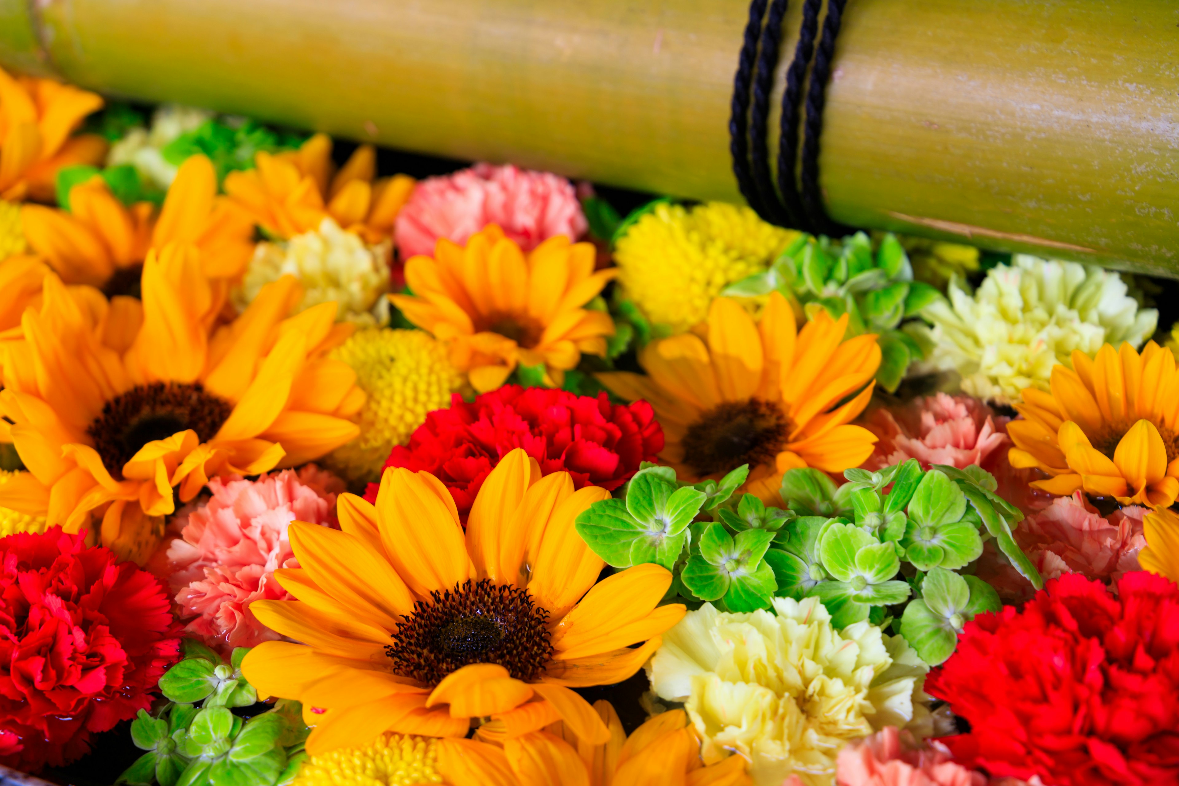 Un hermoso arreglo de flores coloridas y un rollo de bambú