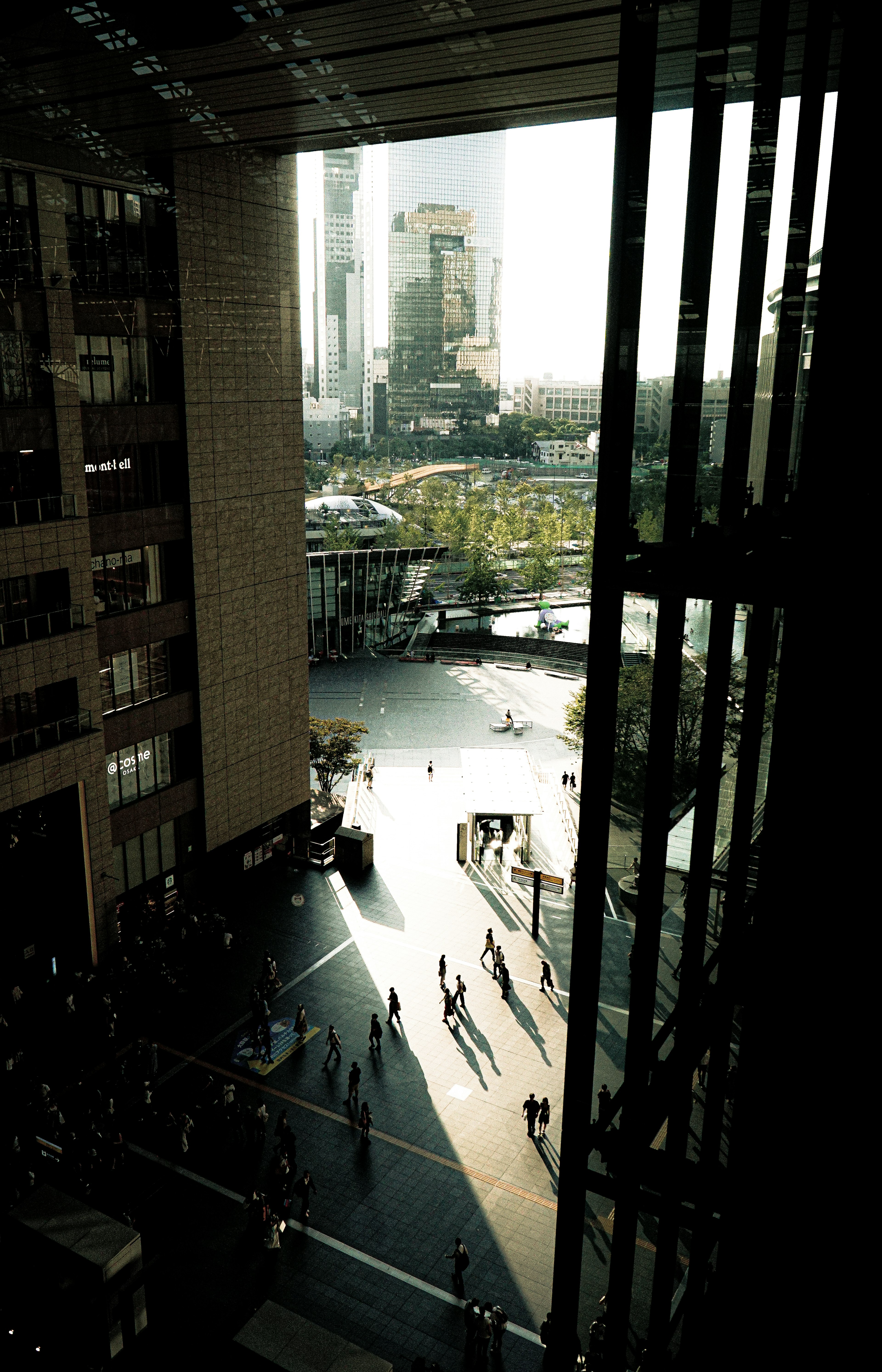 City view with people casting shadows seen through a building