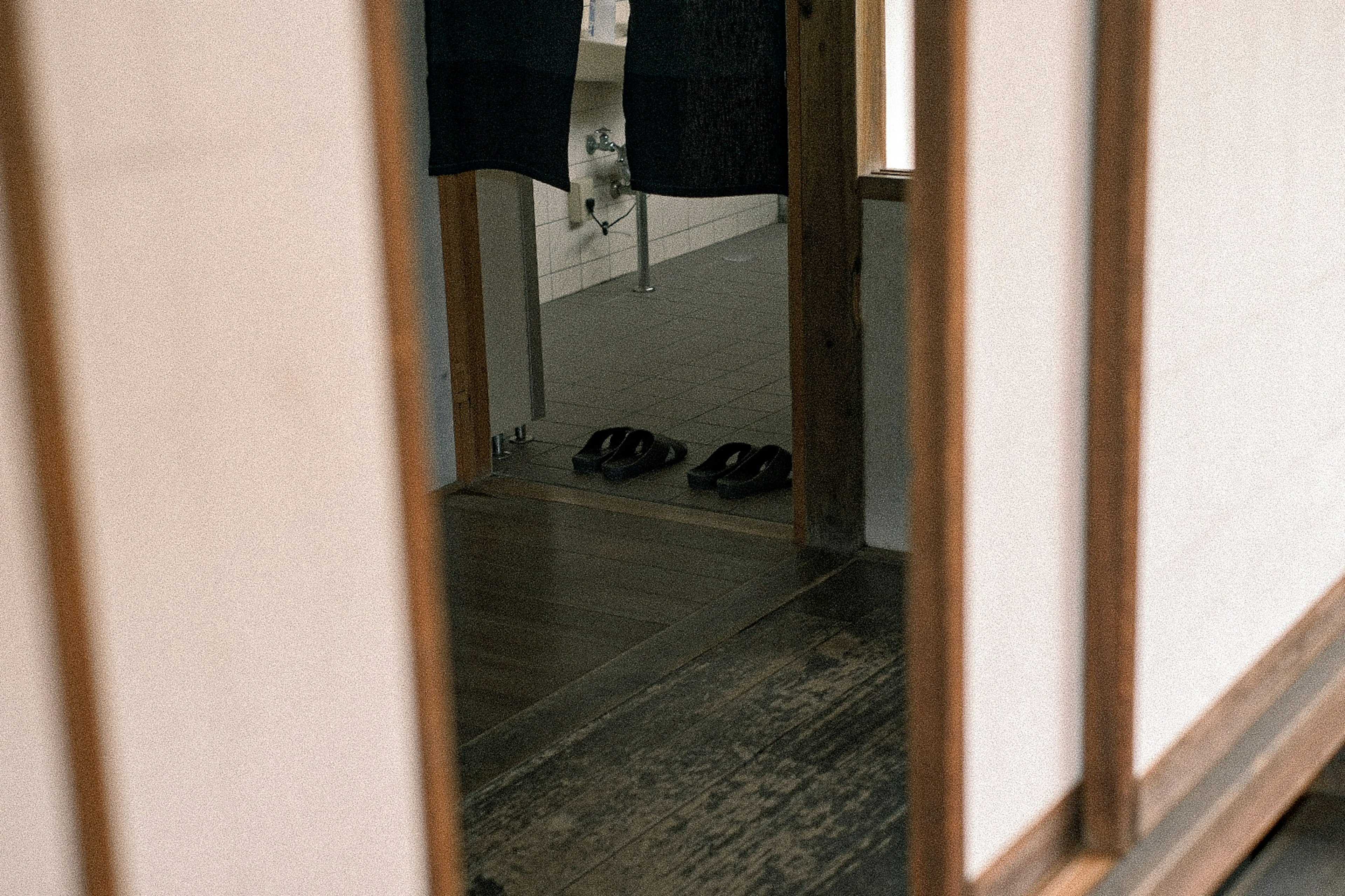 Reflejo de zapatillas y ropa tradicional en un interior japonés