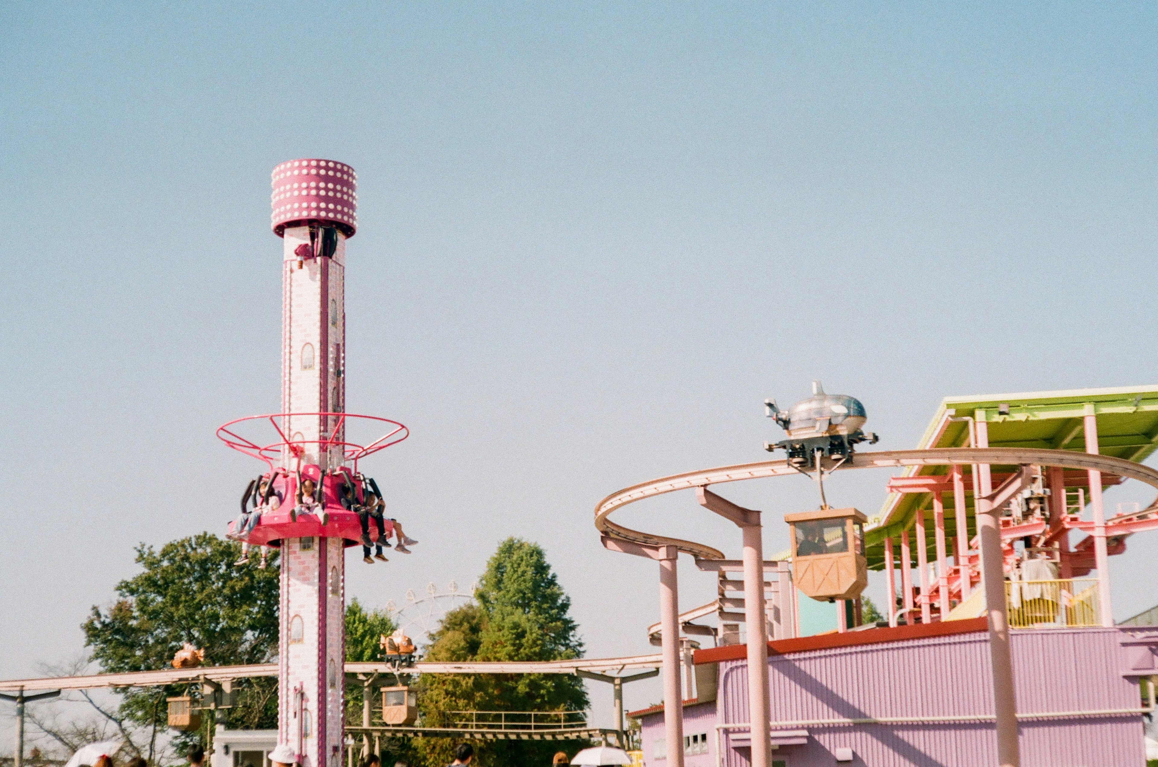 Amusement park featuring a pink ride and clear blue sky