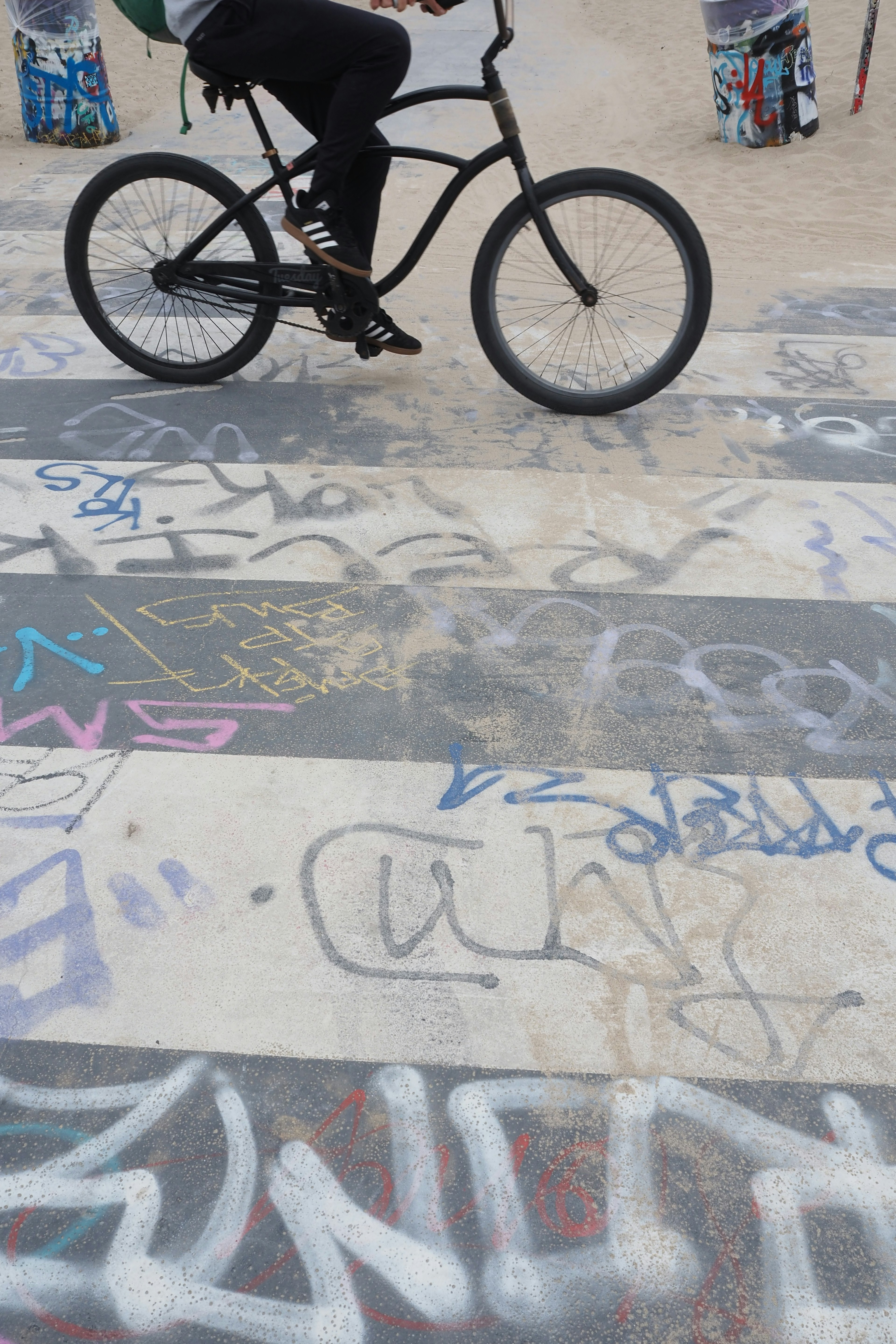 Person riding a bicycle on graffiti-covered pavement