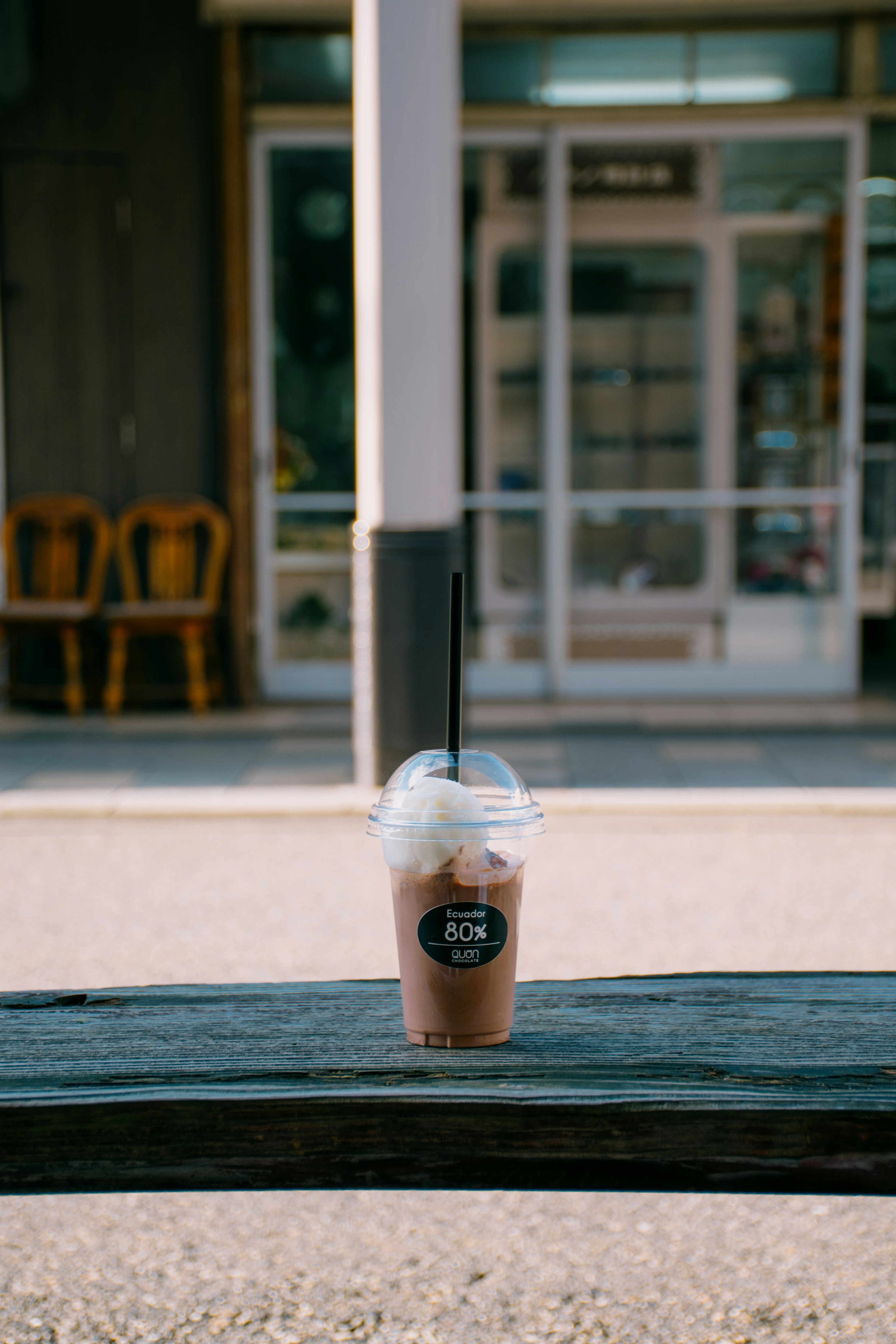 Frappuccino cokelat yang diletakkan di atas meja kayu di depan kafe