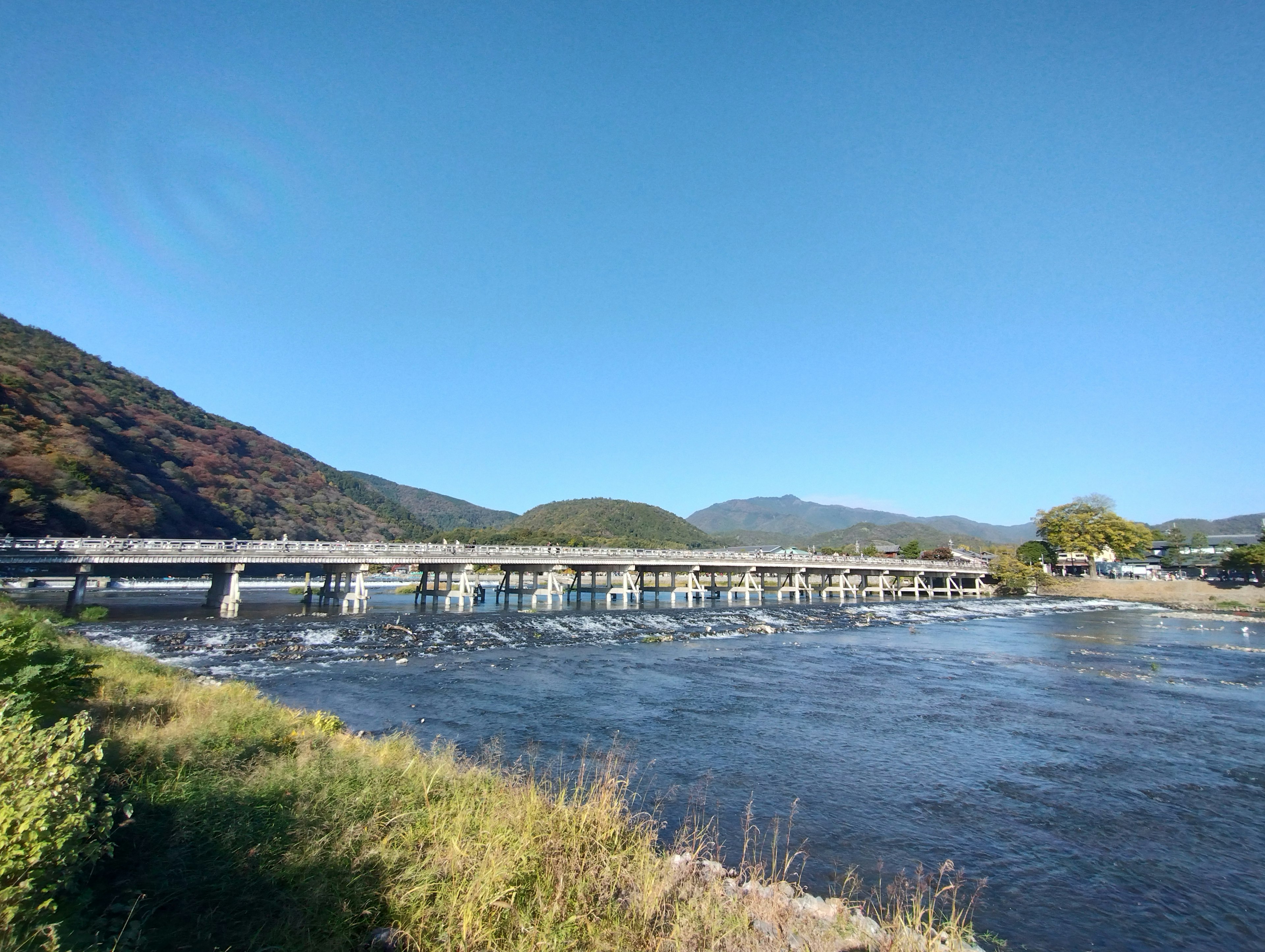 Malersicher Blick auf einen Fluss und eine Brücke unter einem klaren blauen Himmel