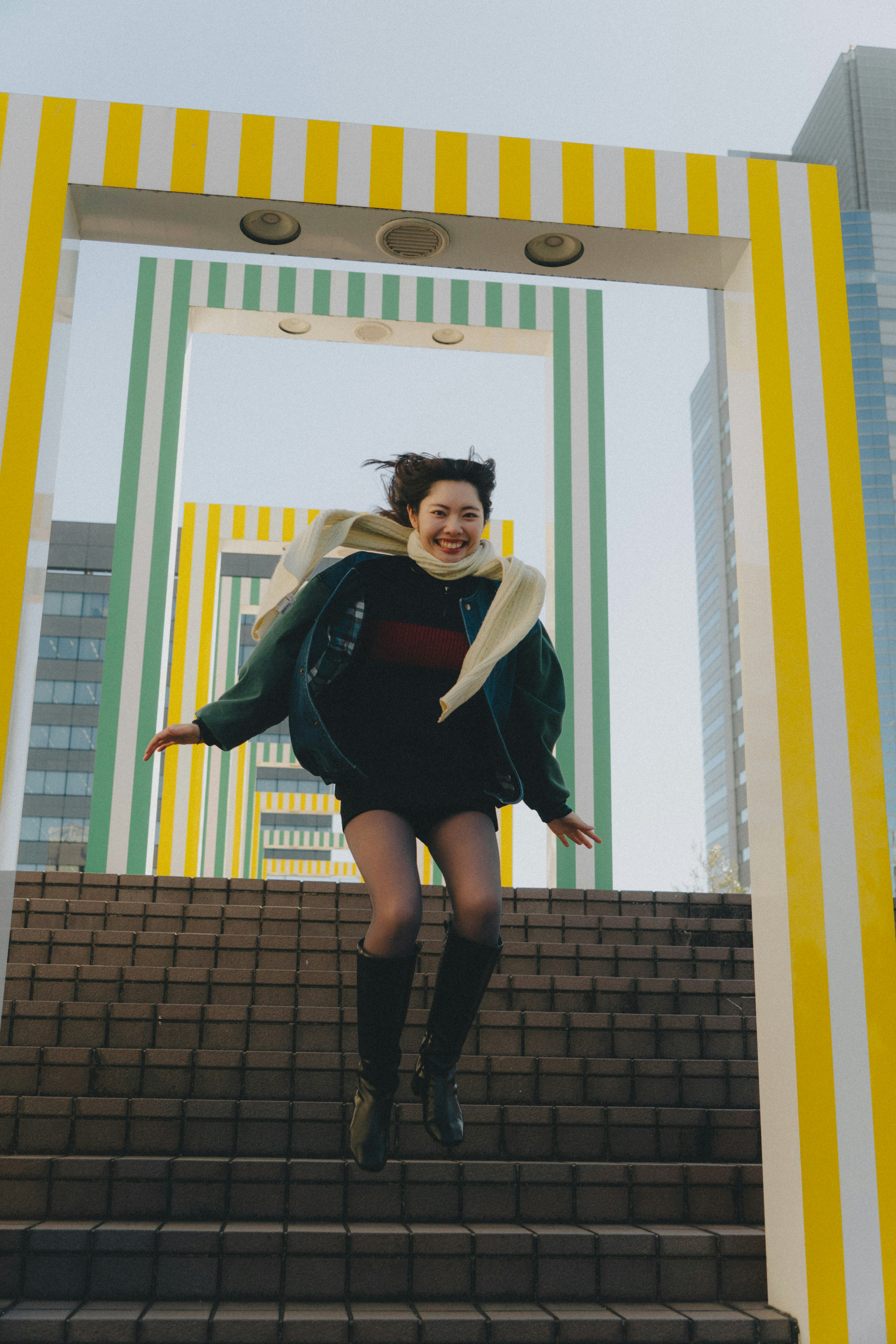 A woman jumping in front of colorful arches