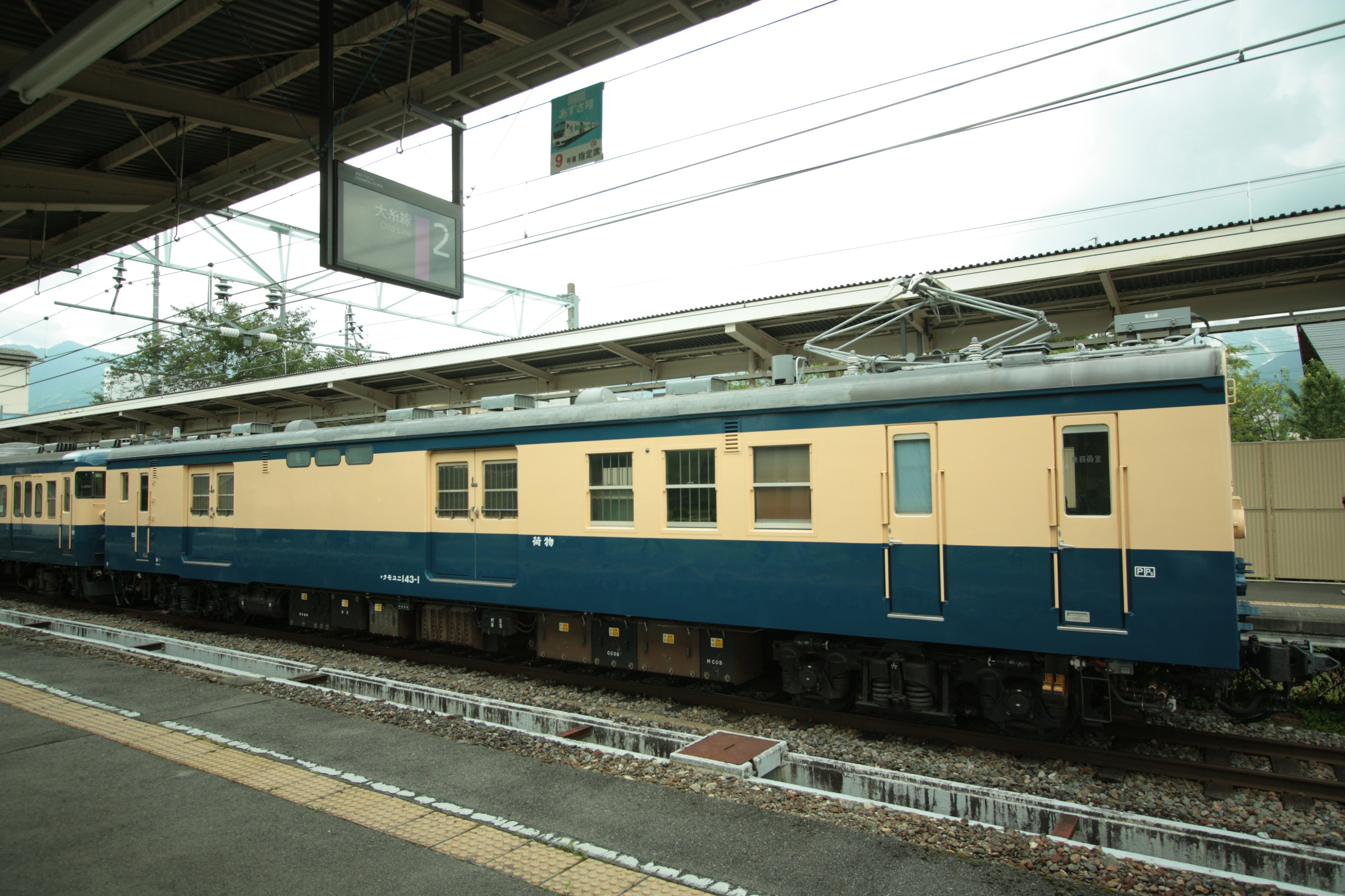 รถไฟสีน้ำเงินและครีมจอดอยู่ที่สถานี