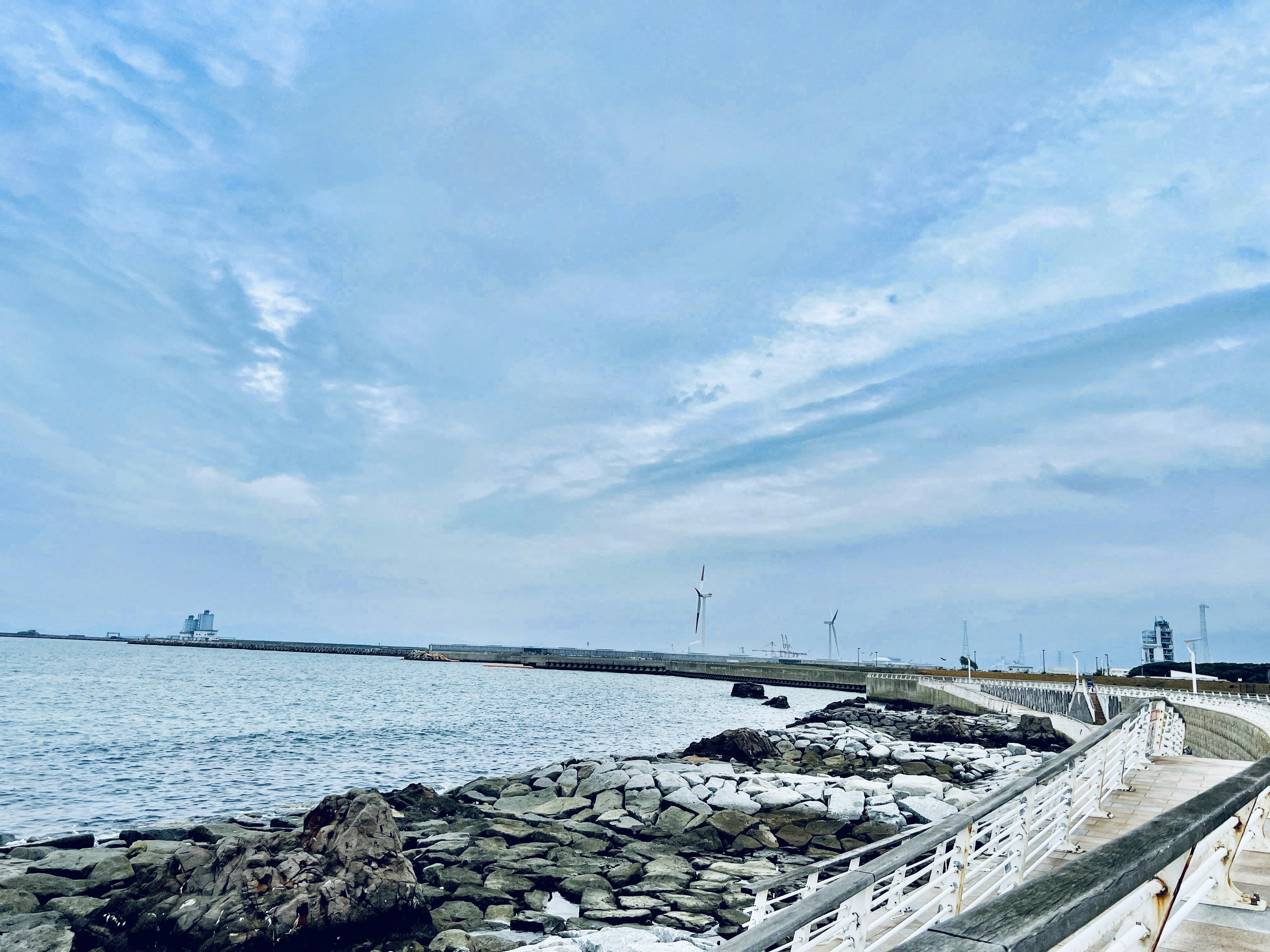 Coastal walkway with rocks and a blue sky