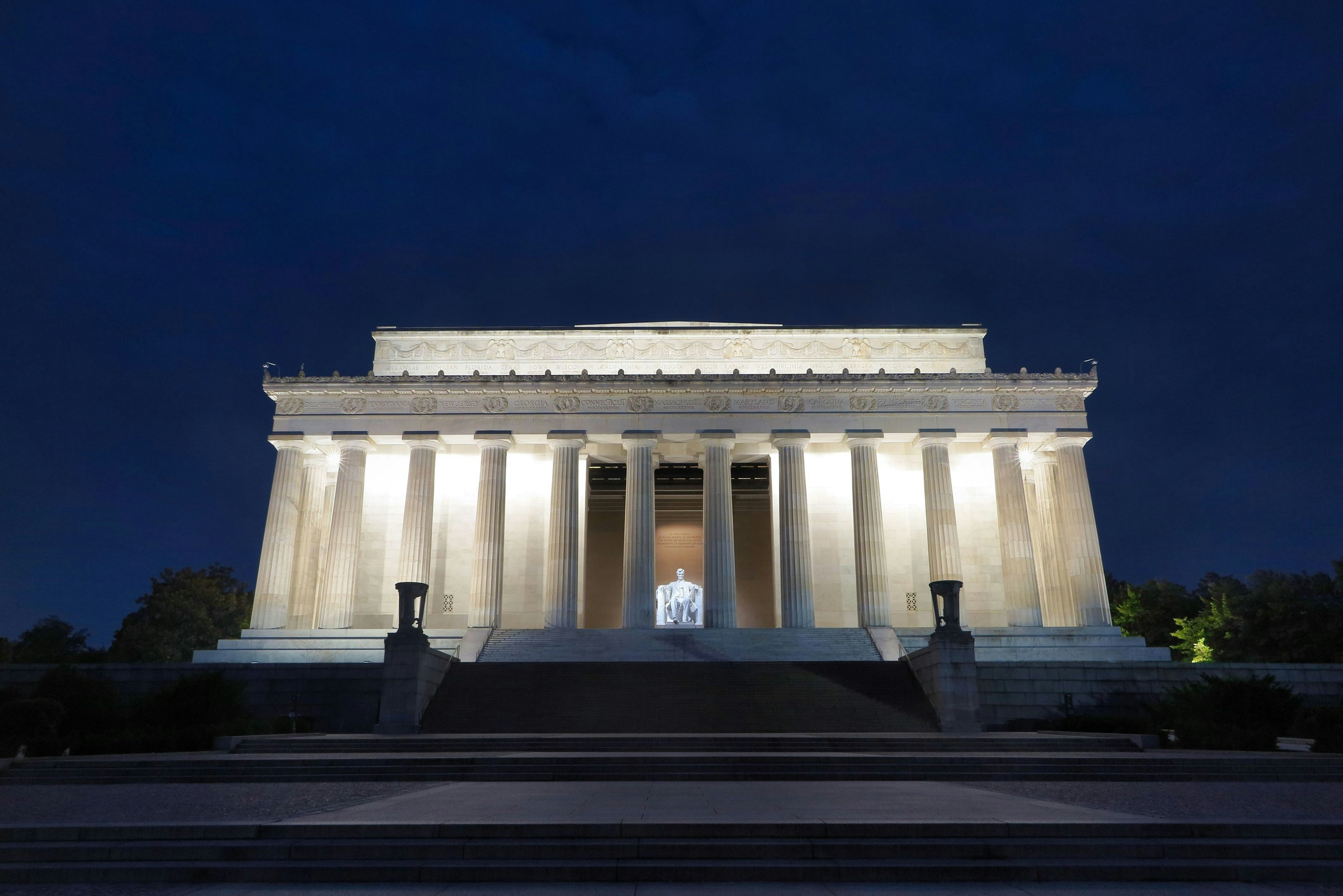 Lincoln Memorial at night with white marble columns and bright lighting