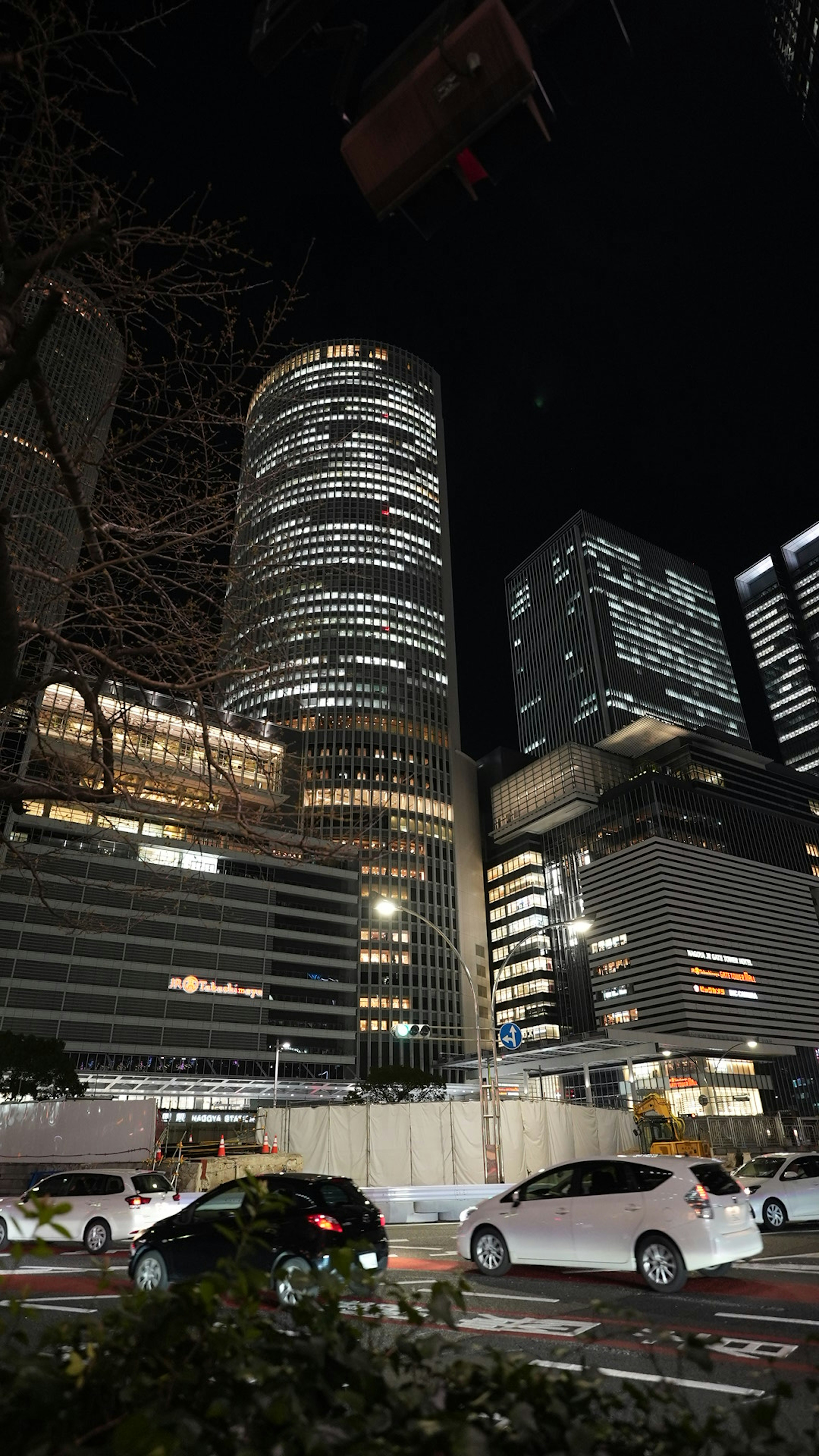 Vue nocturne de gratte-ciels avec fenêtres illuminées et ciel sombre avec circulation