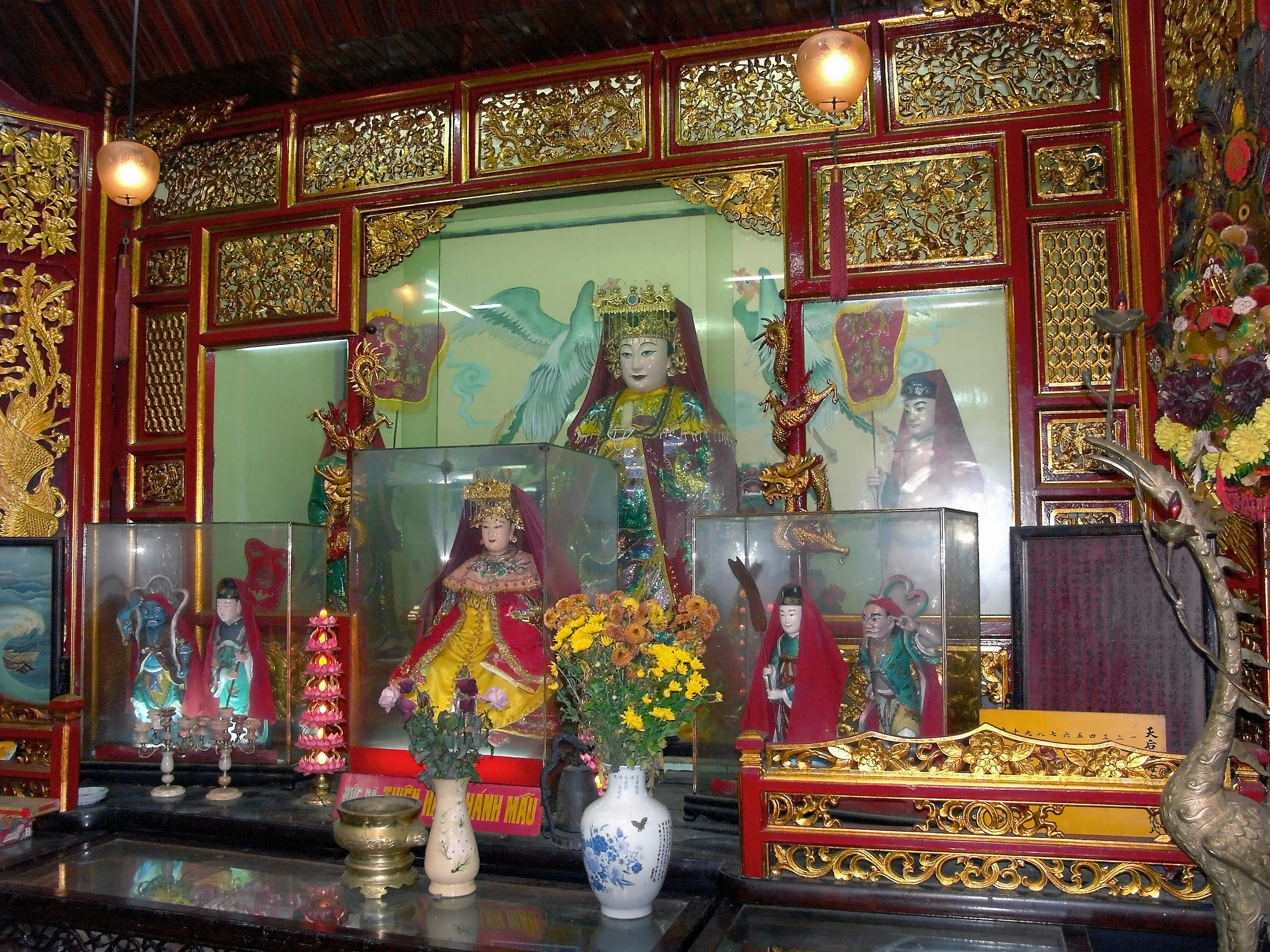 Ornately decorated altar featuring statues and floral arrangements