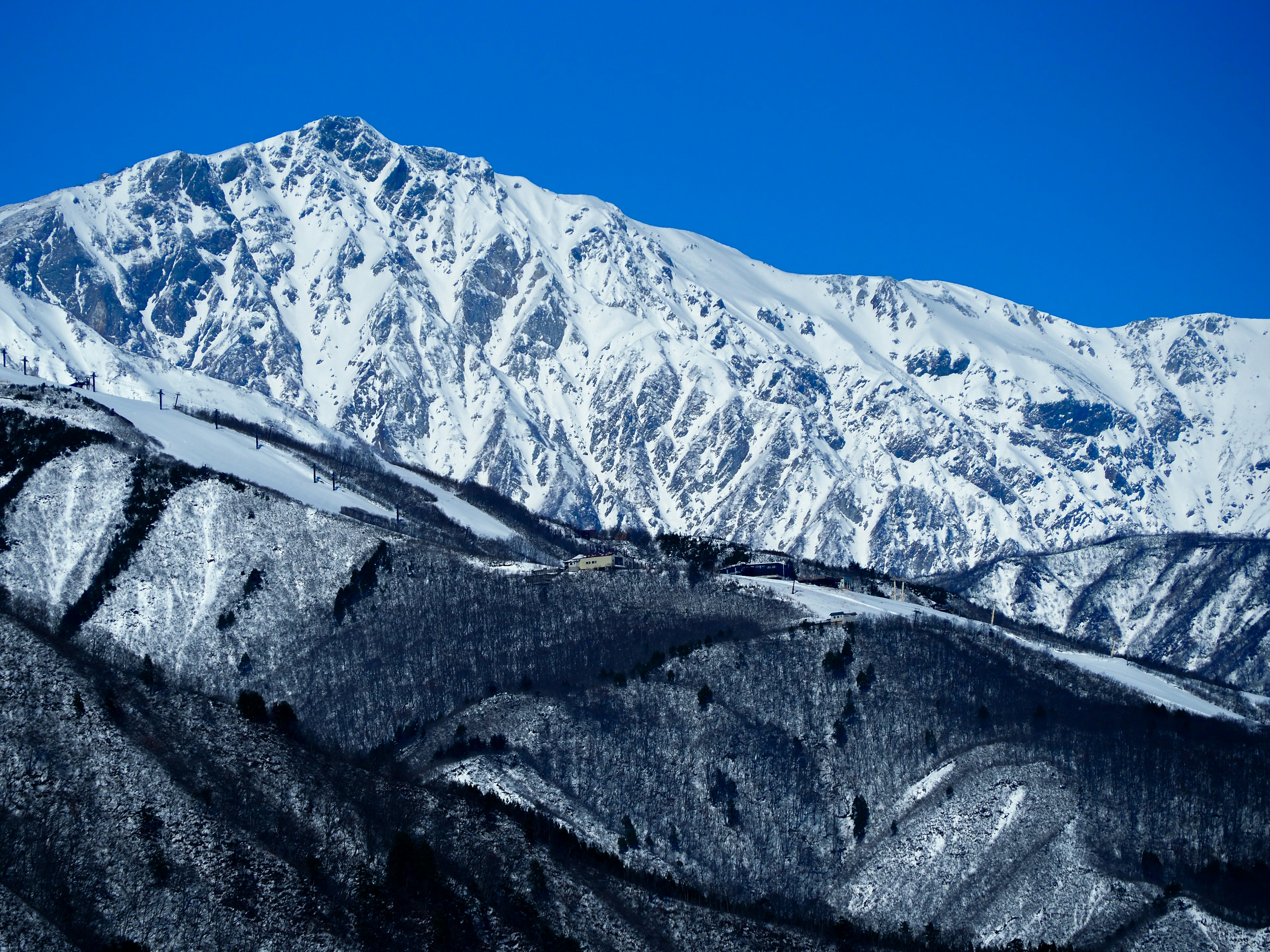 Gunung bersalju di bawah langit biru yang cerah